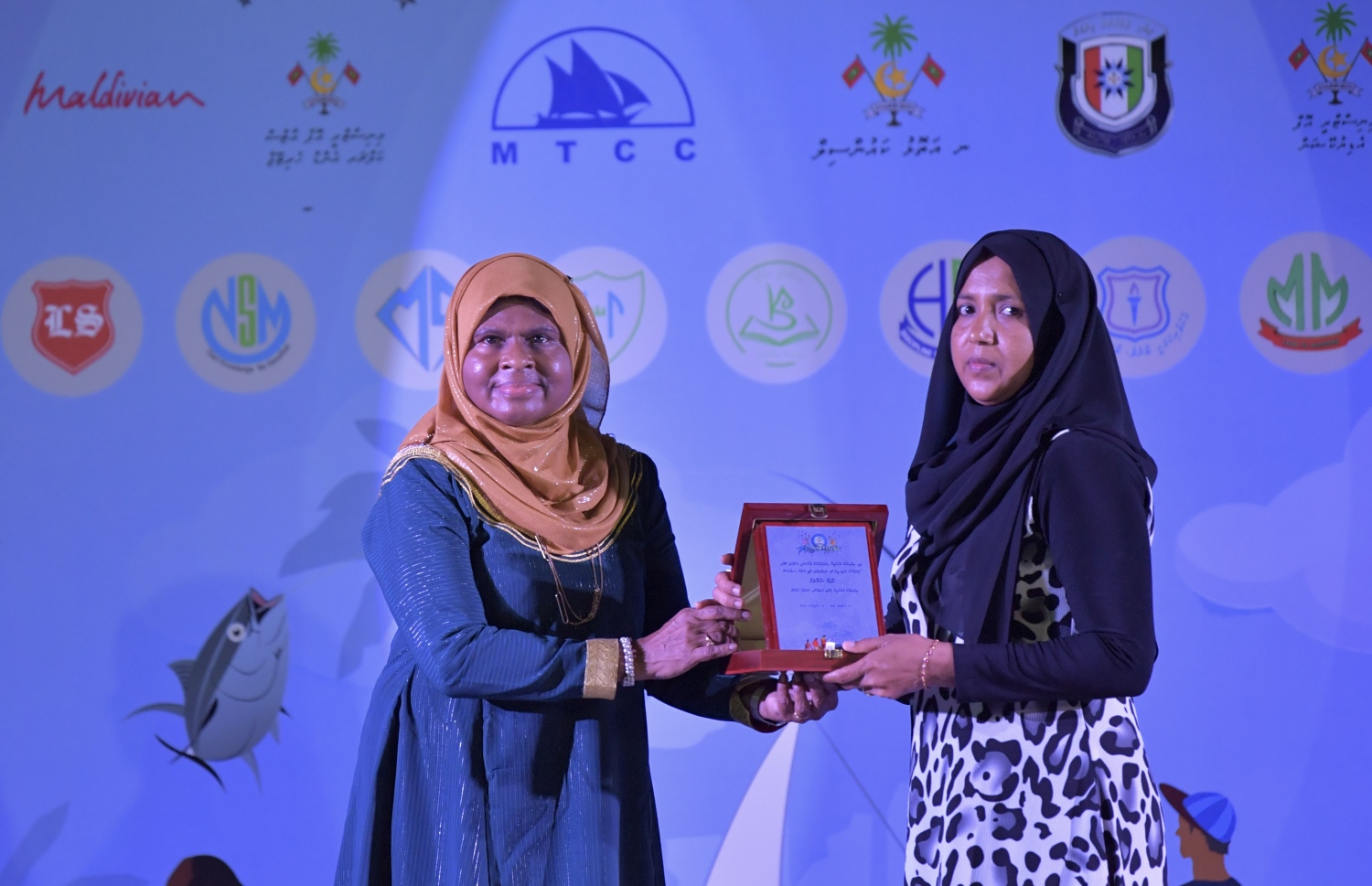 ނ. މަނަދޫ: ސެޕްޓެމްބަރު 14، 2019: މަނަދޫ ބަނދަރު ސަރަޙައްދުގައި ބޭއްވި 'މިލަދެކުނު އަދަބީ އީދު 2019'  ނިންމުމުގެ ޖަލްސާގައި އެ ސްކޫލުގެ ދަރިވަރަކަށް އިނާމު ހަވާލުކޮށްދެއްވަނީ.-- ފޮޓޯ: ރައީސް އޮފީސް