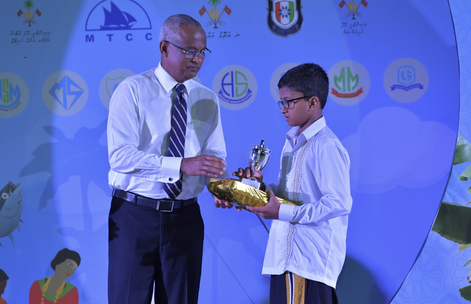 ނ. މަނަދޫ: ސެޕްޓެމްބަރު 14، 2019: މަނަދޫ ބަނދަރު ސަރަޙައްދުގައި ބޭއްވި 'މިލަދެކުނު އަދަބީ އީދު 2019'  ނިންމުމުގެ ޖަލްސާގައި އެ ސްކޫލުގެ ދަރިވަރަކަށް ރައީސް އިބްރާހިމް މުހައްމަދު ސޯލިހު އިނާމު ހަވާލުކޮށްދެއްވަނީ.-- ފޮޓޯ: ރައީސް އޮފީސް