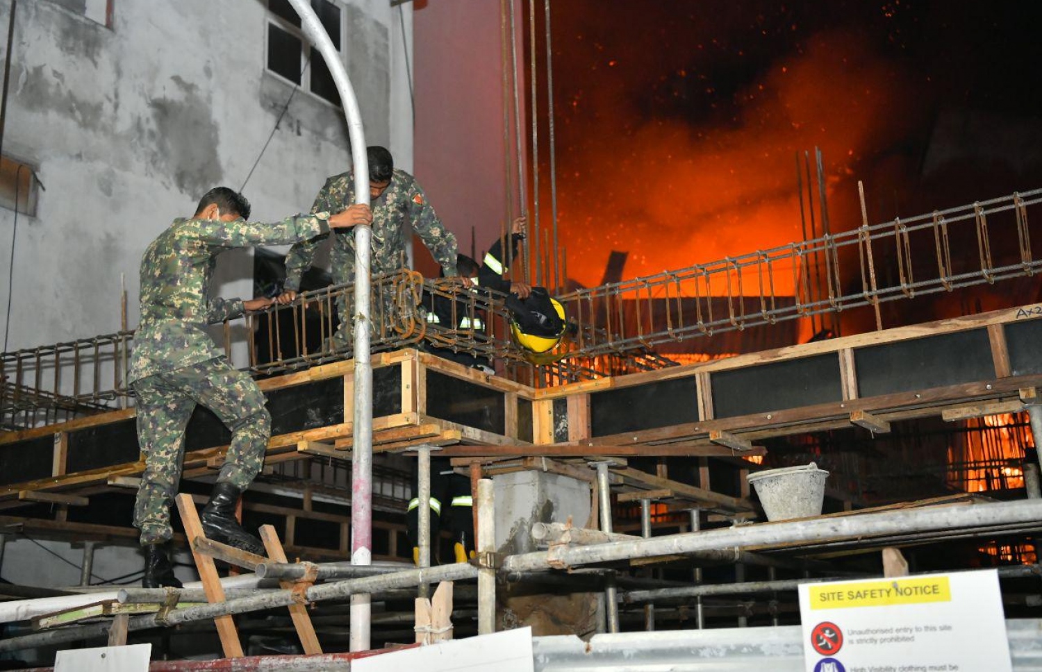 އަބަދަށްފެހި މަގުގައި ހުރި އިމާރާތްތަކުގައި ރޯވެ އަނދަމުންދާ އިރު އަލިފާން ނިންވުމަށް ސިފައިން މަސައްކަތް ކުރަނީ. --ފޮޓޯ: ހުސެއިން ވަހީދު/ މިހާރު