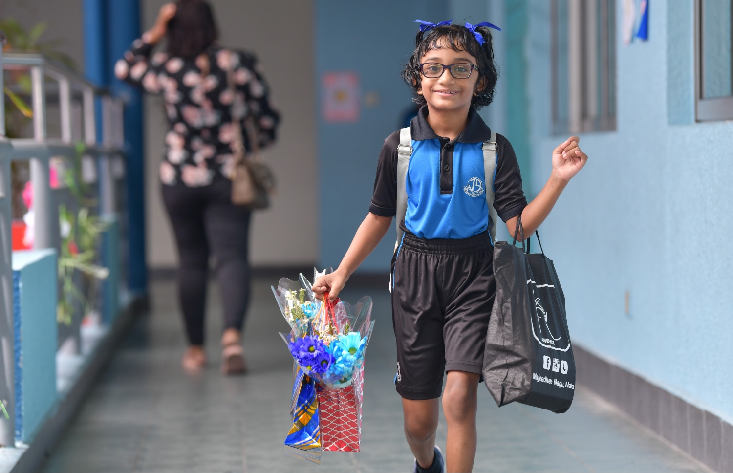 މާލެ: އޮކްޓޯބަރު 6، 2019:ބައިނަލްއަގްވާމީ ޓީޗަރުންގެ ދުވަސް ފާހަގަ ކުރުމުގެ ގޮތުން ޖާމާލުއްދީ ސްކޫލުގެ ކުއްޖަކު މާ ހިފައިގެން ސްކޫލަށް ވަންނަނީ، ރާއްޖޭގެ ސްކޫލުތަކުގައި ބައިނަލްއަގްވާމީ ޓީޗަރުންގެ ދުވަސް މިއަދު ވަރަށް ކުލަގަދަކޮށް ފާހަގަކުރި--.ފޮޓޯ:ނިޝާން އަލީ/މިހާރު