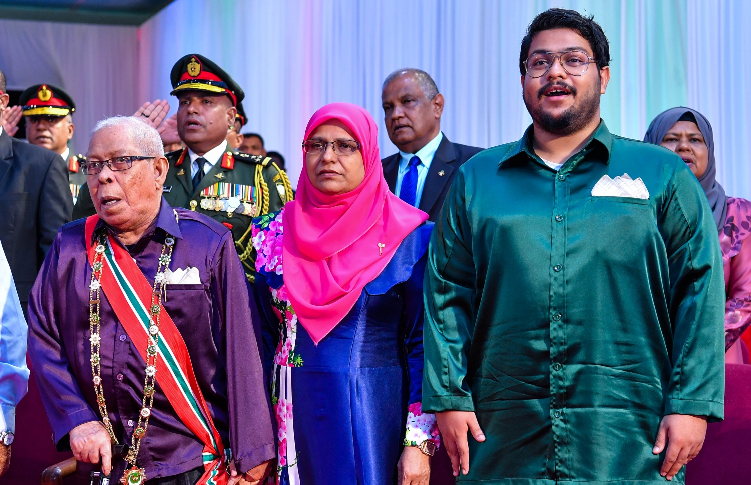 ރައުފަތު (ކ) އޭނާގެ ބައްޕަ ސޯދުބެ (ވ) އާއި މަންމަ މުނީރާއާ އެކު ގައުމީ ދުވަހުގެ ޖަލްސާގައި. --ފޮޓޯ: ރައީސް އޮފީސް