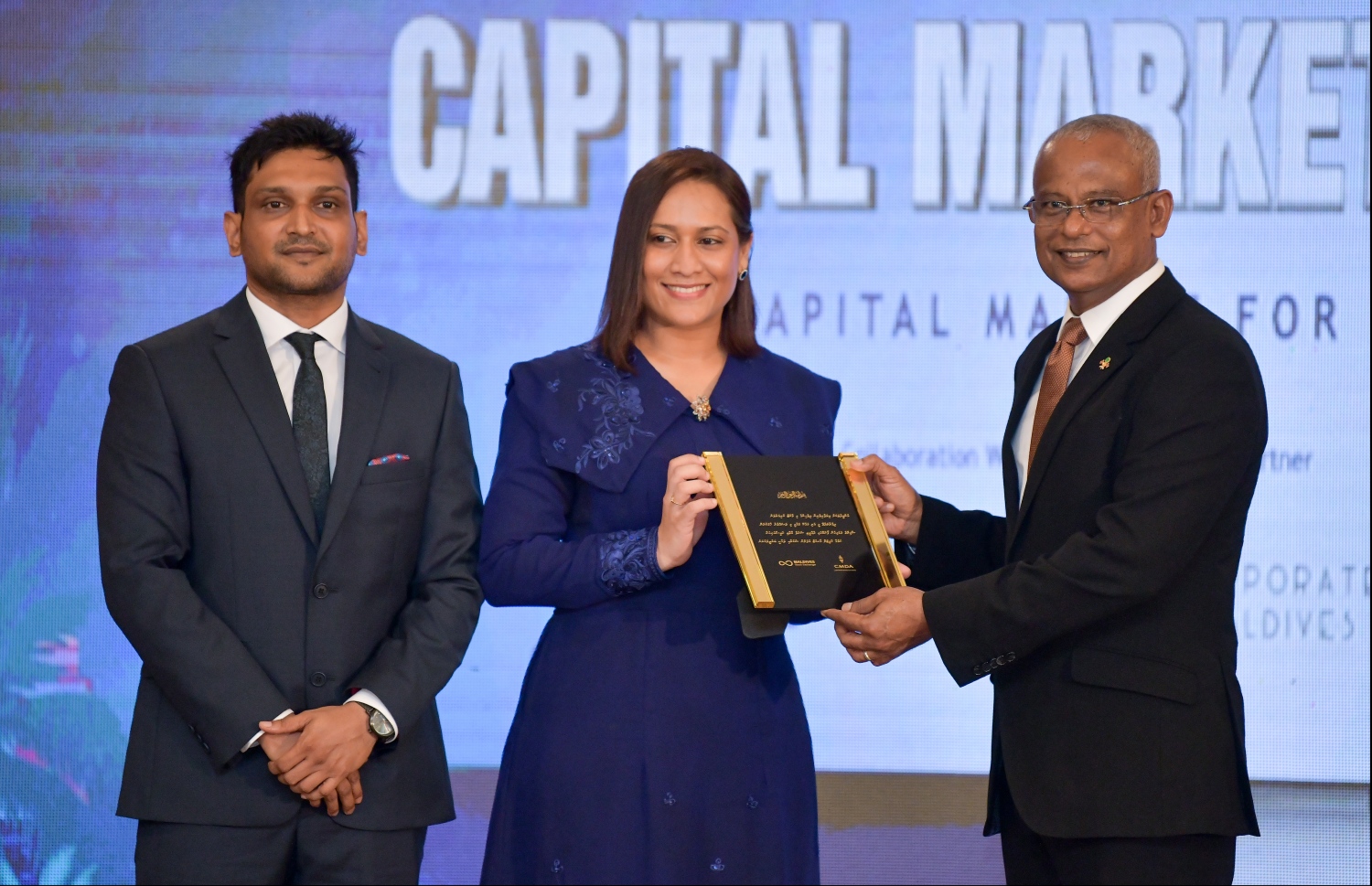 ބަނޑޮސް އައިލެންޑް ރިސޯޓް: އޮކްޓޯބަރު 31، 2019: "ކެޕިޓަލް މާކެޓް ފޯރަމް 2019"ގައި ފޯރަމް އިންތިޒާމުކުރި ފަރާތުން އަރުވާ ހަނދާނީ ފިލައެއް، ސީއެމްޑީއޭގެ އެކްޓިން ސީއީއޯ ފާތިމަތު އަބްދުﷲ ކަމާލުއްދީން، ރައީސް އިބްރާޙިމް މުހައްމަދު ސޯލިހް އަށް ދެއްވާއިރު އަރިހުގައި މޯލްޑިވްސް ސްޓޮކް އެކްސްޗޭންޖުގެ ސީއީއޯ އައުޝަން ލަތީފް..--- ފޮޓޯ: ހުސައިން ވަހީދު /މިހާރު