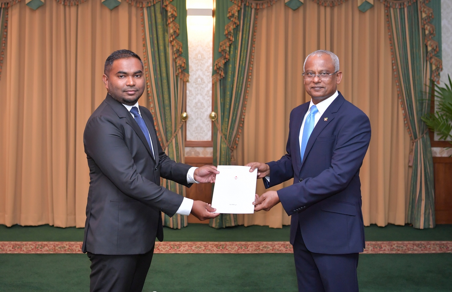 ސުޕްރީމް ކޯޓުގެ ފަނޑިޔާރު ކަމަށް މިއަދު އައްޔަންކުރެއްވި މަހާޒް އަލީ ޒާހިރަށް، ފަނޑިޔާރުކަމުގެ ލިޔުން ރައީސް ހަވާލުކުރައްވަނީ.-- ފޮޓޯ: ރައީސް އޮފީސް