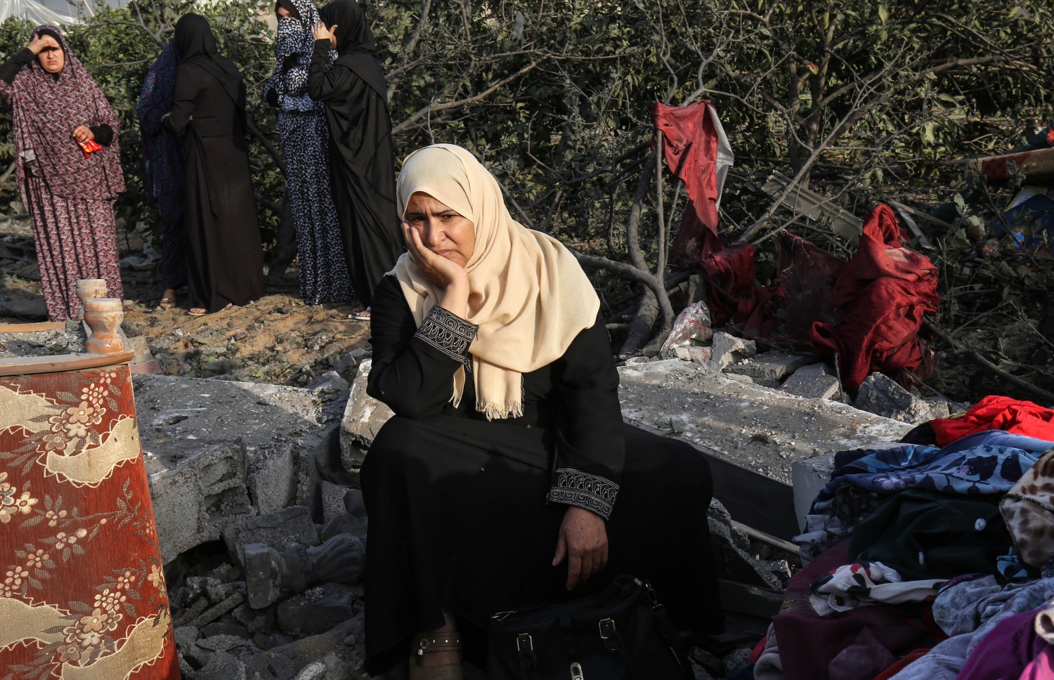 އިޒްރޭލުގެ ވައިގެ ހަމަލާތަކުގައި ބިމާ ހަމަކޮށްލާފައިވާ އިމާރާތެއްގެ ކައިރީ ފަލަސްތީނުގެ އަންހެނުންތަކެއް މަޑުކޮށްލައިގެން. --ފޮޓޯ:އޭއެފްޕީ