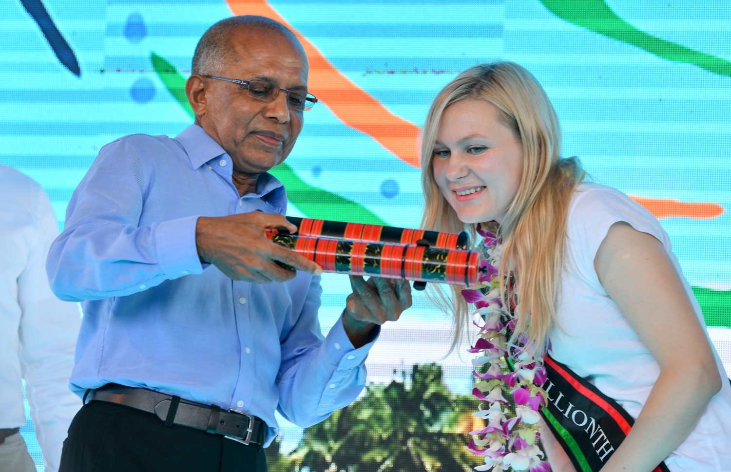 ހުޅުލެ، ވެލާނާ އިންޓަނޭޝަނަލް އެއާޕޯޓު: ނޮވެމްބަރު 24، 2019: ރާއްޖޭގެ ތާރީޚުގައި ފުރަތަމަ ފަހަރަށް އަހަރެއްގެ ތެރޭގައި އައި ޓޫރިސްޓުންގެ އަދަދު ދޮޅު މިލިއަނަށް އެރުމާއި ގުޅިގެން، އެކަން ފާހަގަ ކުރުމަށް ބޭއްވި ހަފުލާގައި 1.5 މިލިއަން ވަނަ ޓޫރިސްޓަކަށް ވި ރަޝިއާގެ އަންހެނެއް ކަމަށް ވާ މަރީނާ ކަޒަކޯވާ އަށް މޯލްޑިވްސް އެސޯސިއޭޝަން އޮފް ޓޫރިޒަމް އިންޑަސްޓްރީގެ ސެކެޓްރީ ޖެނެރަލް އަހުމަދު ނަޒީރު ހާއްސަ ހަދިޔާއެއް އަރުވަނީ.-- ފޮޓޯ: ނިޝާން އަލީ /މިހާރު