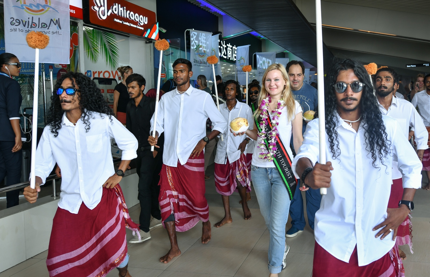 ހުޅުލެ، ވެލާނާ އިންޓަނޭޝަނަލް އެއާޕޯޓު: ނޮވެމްބަރު 24، 2019: ރާއްޖޭގެ ތާރީޚުގައި ފުރަތަމަ ފަހަރަށް އަހަރެއްގެ ތެރޭގައި އައި ޓޫރިސްޓުންގެ އަދަދު ދޮޅު މިލިއަނަށް އެރުމާއި ގުޅިގެން، އެކަން ފާހަގަ ކުރުމަށް ބޭއްވި ހަފުލާގައި 1.5 މިލިއަން ވަނަ ޓޫރިސްޓަކަށް ވި ރަޝިއާގެ އަންހެނެއް ކަމަށް ވާ މަރީނާ ކަޒަކޯވާ އަށް ސަގާފީ ބޮޑުބެރަކާއެކު މަރުހަބާ ކިޔަނީ.-- ފޮޓޯ: ނިޝާން އަލީ /މިހާރު