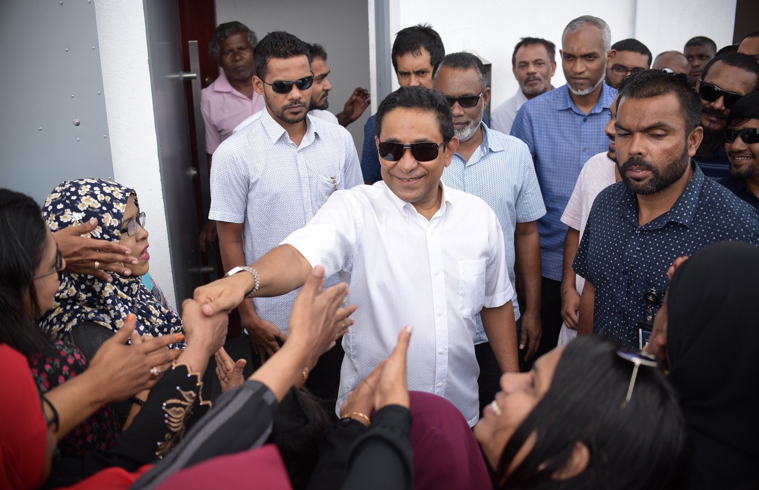 މާލެ: ނޮވެމްބަރު 28، 2019: ކުރީގެ ރައީސް ޔާމީނަށް ހުކުމް އިއްވުމުގެ ޝަރީއަތަށް ކްރިމިނަލް ކޯޓަށް ވަޑައިގަތުމުގެ ކުރިން އެމަނިކުފާނުގެ ސަޕޯޓަރުންނާ ސަލާމް ކުރައްވަނީ.---ފޮޓޯ: ނިޝާން އަލީ/މިހާރު