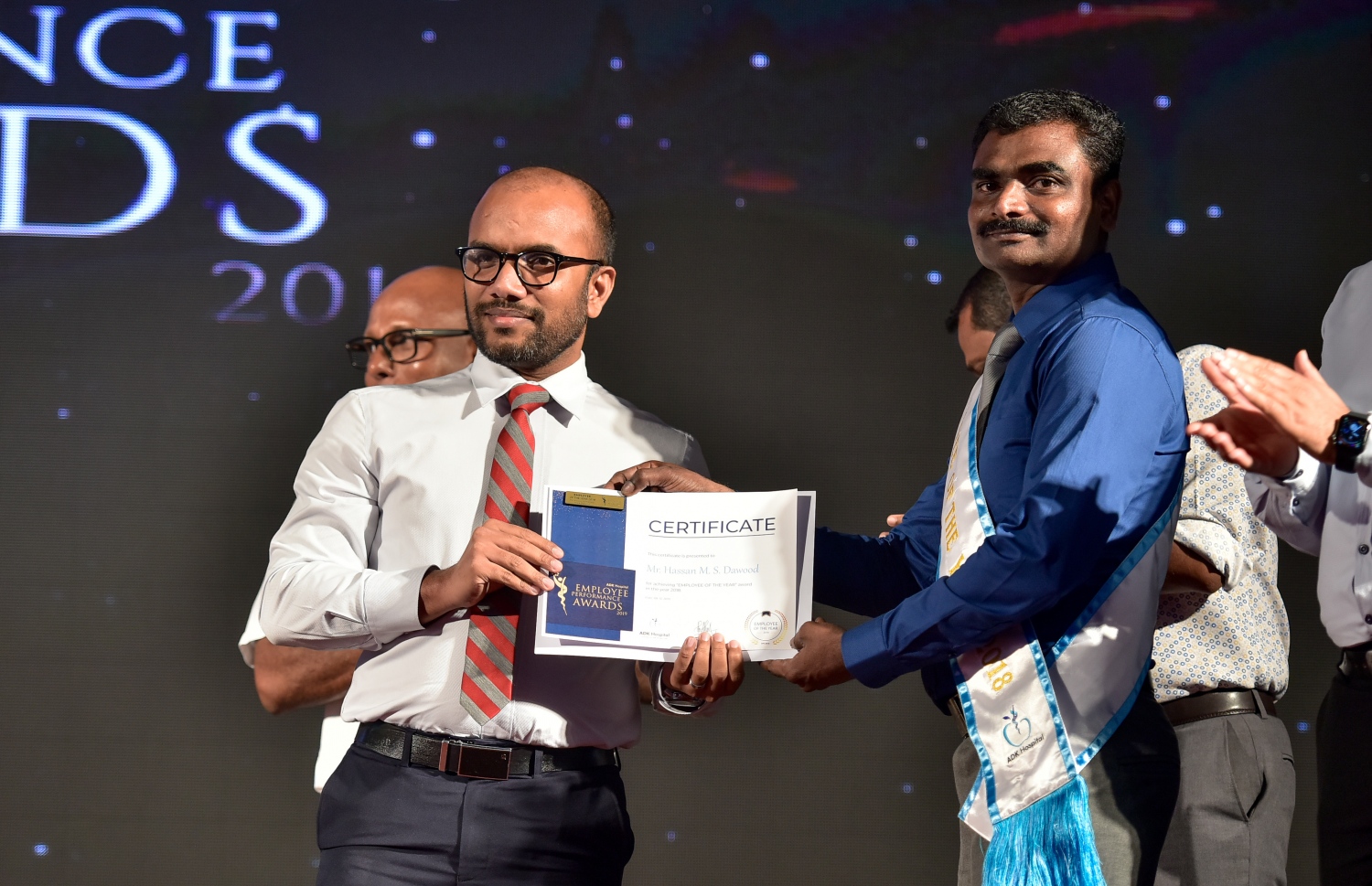 މާލެ- ޑިސެމްބަރު 8، 2019: އޭޑީކޭ ހޮސްޕިޓަލްގެ މިދިޔަ އަހަރުގެ އެންމެ ރަނގަޅު މުވައްޒަފަކަށް ހޮވި ހަސަން މުހައްމަދު ޝެއިޚް ދާއޫދު އަށް ފިނޭންސް މިނިސްޓަރު އަމީރު މިރޭ އިނާމް ދެއްވަނީ.--- ފޮޓޯ: ނިޝާން އަލީ/ މިހާރު