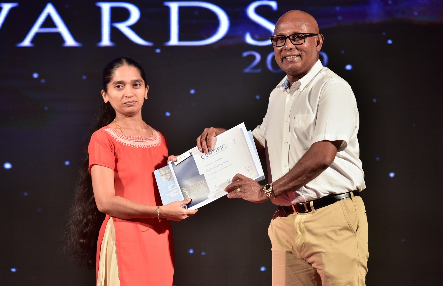 މާލެ-ޑިސެމްބަރު 8، 2019 : އޭޑީކޭ ހޮސްޕިޓަލްގެ މުވައްޒަފުންގެ އަގު ވަޒަން ކުރަން ބޭއްވި ހަފްލާގައި އެހޮސްޕިޓަލްގެ މިދިޔަ އަހަރު ޕާފޯމަންސް އެވޯޑު ލިބުނު މުވައްޒަފަކާ އޭޑީކޭގެ ޗެއާމަން ނާޝިދު އިނާމު ހަވާލު ކޮށްދެއްވަނީ --. ފޮޓޯ: ނިޝާން އަލީ/ މިހާރު