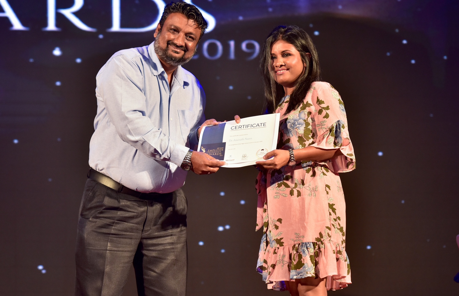 މާލެ- ޑިސެމްބަރު 8، 2019: އޭޑީކޭ ހޮސްޕިޓަލްގެ މުވައްޒަފުންގެ އަގު ވަޒަން ކުރަން ބޭއްވި ހަފްލާގައި އެހޮސްޕިޓަލްގެ މިދިޔަ އަހަރު ޕާފޯމަންސް އެވޯޑު ލިބުނު މުވައްޒަފަކާ އިނާމު ހަވާލު ކުރައްވަނީ --. ފޮޓޯ: ނިޝާން އަލީ/ މިހާރު