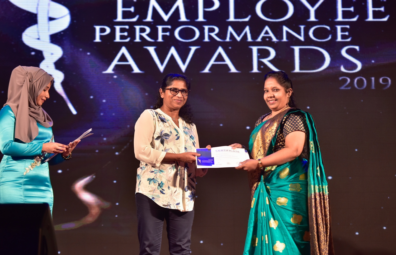 މާލެ- ޑިސެމްބަރު 8، 2019: އޭޑީކޭ ހޮސްޕިޓަލްގެ މުވައްޒަފުންގެ އަގު ވަޒަން ކުރަން ބޭއްވި ހަފްލާގައި އެހޮސްޕިޓަލްގެ މިދިޔަ އަހަރު ޕާފޯމަންސް އެވޯޑު ލިބުނު މުވައްޒަފަކާ އިނާމު ހަވާލު ކުރައްވަނީ --. ފޮޓޯ: ނިޝާން އަލީ/ މިހާރު