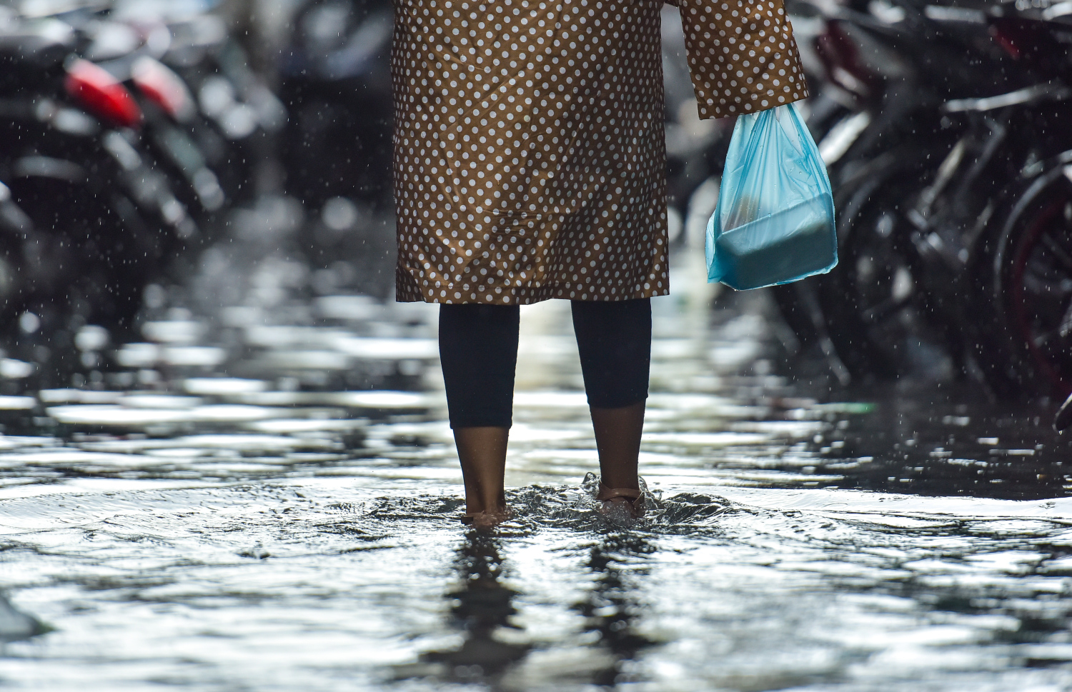 ވާރޭގައި މާލޭގައި ފެންބޮޑުވެފައި އޮތް މަގަކުން މީހަކު ހިނގާފައި ދަނީ.-- ފޮޓޯ: މިހާރު