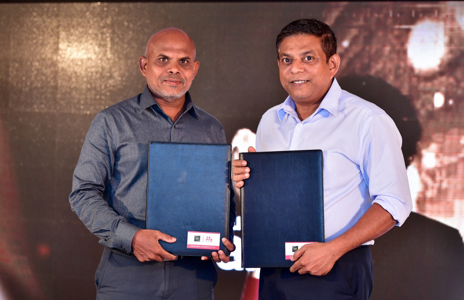 މާލެ: ޑިސެމްބަރު 22، 2019: ރާއްޖޭގެ ކުޅިވަރުގައި ދެވޭ އެންމެ ޝަރަފްވެރި އަދި އެންމެ ބޮޑު އެވޯޑްސް ކަމަށްވާ މިހާރު އެވޯޑްސްގެ މި އަހަރުގެ އިވެންޓުގެ ސްޕޮންސަރުންނާ އެކު އެއްބަސްވުމުގައި ސޮއިކުރުމަށް ބޭއްވި ރަސްމިއްޔާތުގައި މިހާރުގެ އެޑިޓަރު މޫސާ ލަތީފް (ވ) އާއި ސޮނީ ސްޕޯޓްސްގެ އިބްރާހިމް ކަލޭފާނު އެއްބަސްވުން ދައްކާލަނީ --. ފޮޓޯ:ނިޝާން އަލީ/މިހާރު