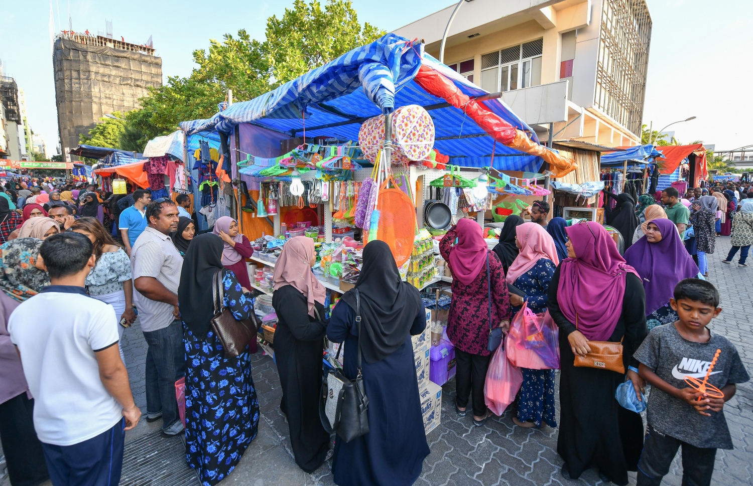ރަސްފަންނުގައި ބޭއްވި ނައިޓް މާކެޓްގައި ބަޔަކު ވިޔަފާރީކުރަން މޭޒެއް ކައިރީގައި މަޑުކޮށްލައިގެން.-- ފައިލް ފޮޓޯ: ނިޝާން އަލީ/މިހާރު