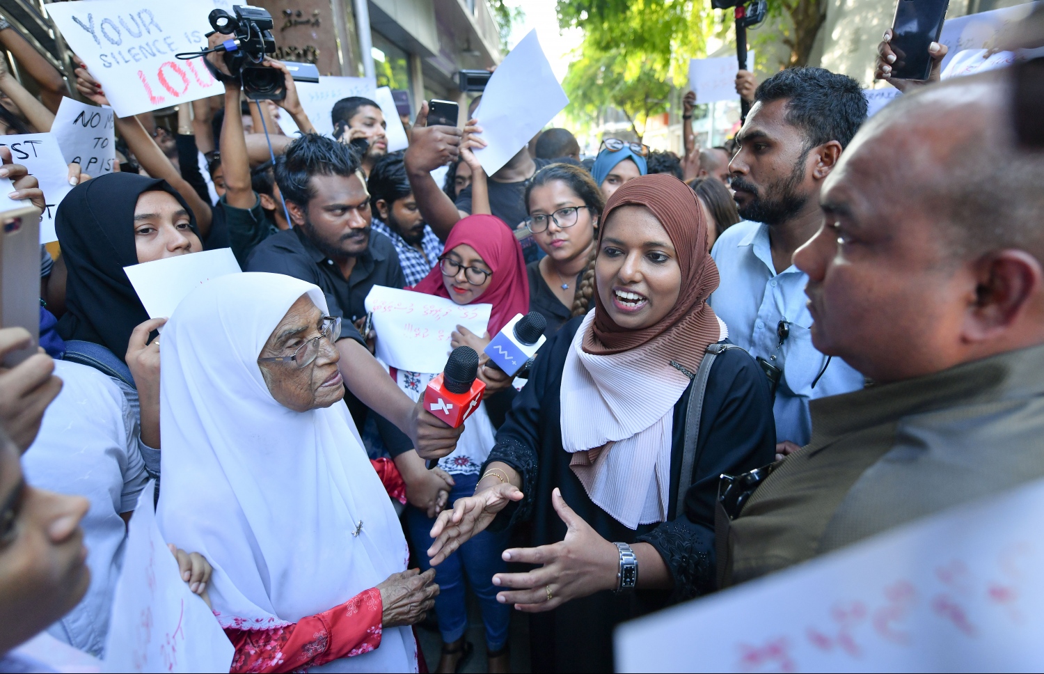 މާލެ ޖެނުއަރީ 17، 2020: ގއ. ކަނޑުހުޅުދޫގައި ދެ އަހަރުގެ އަންހެން ކުއްޖަކު ރޭޕް ކުރި މައްސަލަ އާއި ގުޅިގެން މިއަދު މާލޭގައި ޗައިލްޑް އެބިއުޒް އާ ދެކޮޅަށް ކުރި މުޒާހަރާގެ އެއްވެ ތިބި މީހުންނާއި ޖެންޑަ މިނިސްޓަރު ޝިދާތާ އެ ސަރަހައްދަށް ވަޑައިގެން ބައްދަލު ކުރައްވަނީ: އެއްވި މީހުން ވަނީ ޖެންޑަ މިނިސްޓްރީން އިހުމާލުވެފައިވާ ކަމަށް ބުނެ، އެތަނުގެ ވެރިން ވަގުތުން އިސްތިއުފާ ދިނުމަށް ގޮވާލައިފައި--. ފޮޓޯ:ނިޝާން އަލީ/މިހާރު