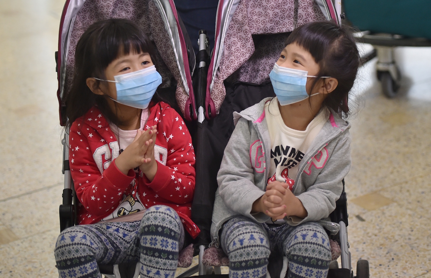 ޗައިނާގެ ވުހާން އިން ސިޑްނީ އަށް ދަތުރުކުރި ދެ ކުޑަ ކުއްޖަކު ފޭސްކް މާސްކުގައި. --ފޮޓޯ:އޭއެފްޕީ