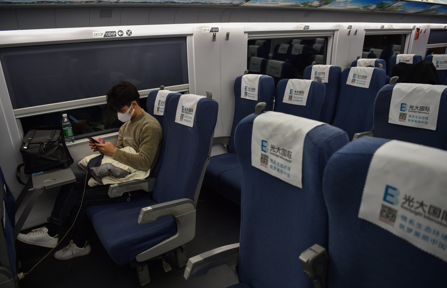 ޗައިނާގެ ވުހާން ސިޓީގެ ރޭލެއްގެ ތެރޭގައި މީހަކު ފޭސްކް މާސްކް އަޅައިގެން. --ފޮޓޯ:އޭއެފްޕީ