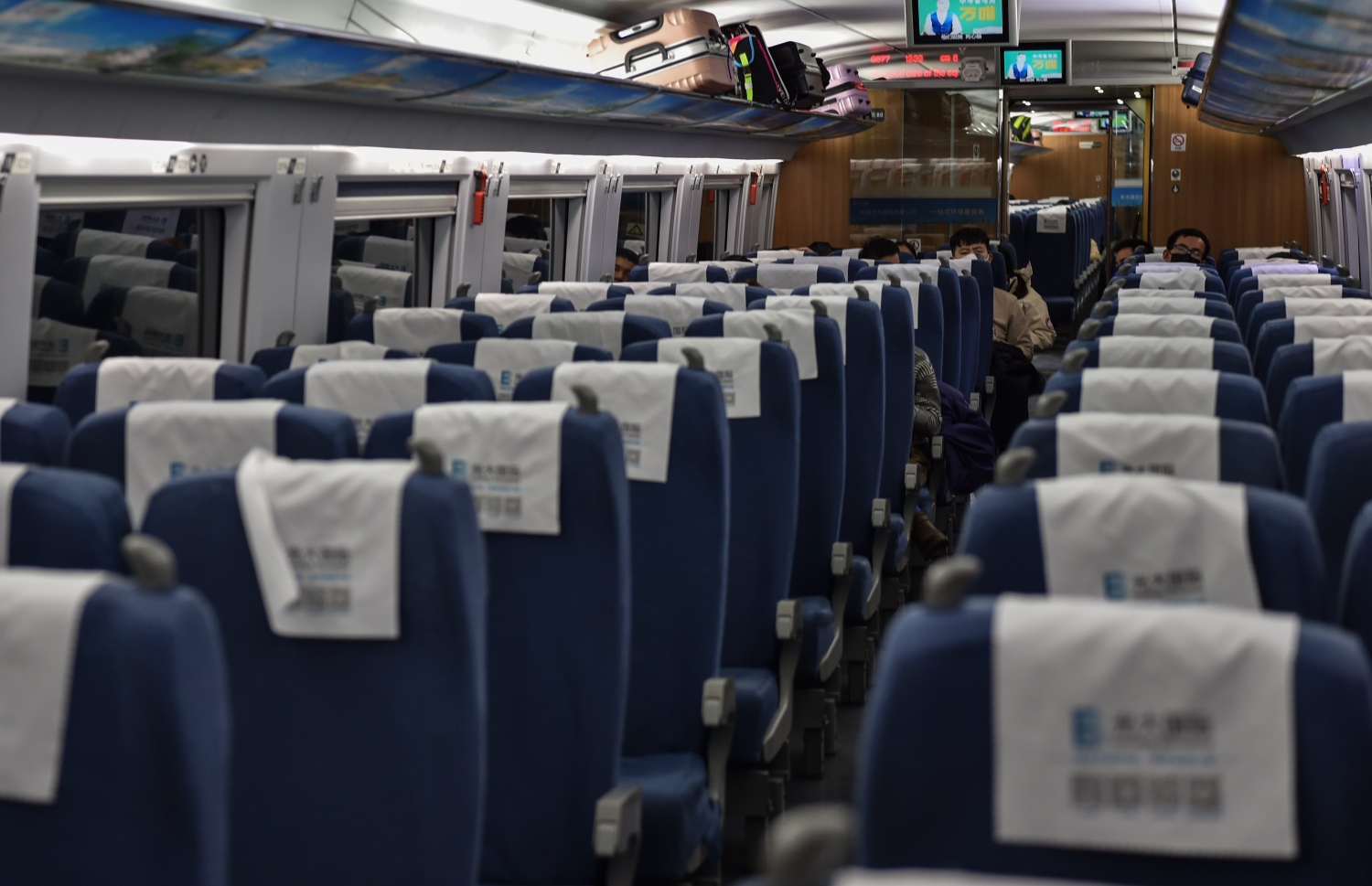 ޗައިނާގެ ވުހާން ސިޓީގެ ރޭލެއްގެ ތެރޭގައި މީހުން ފޭސްކް މާސްކް އަޅައިގެން. --ފޮޓޯ:އޭއެފްޕީ