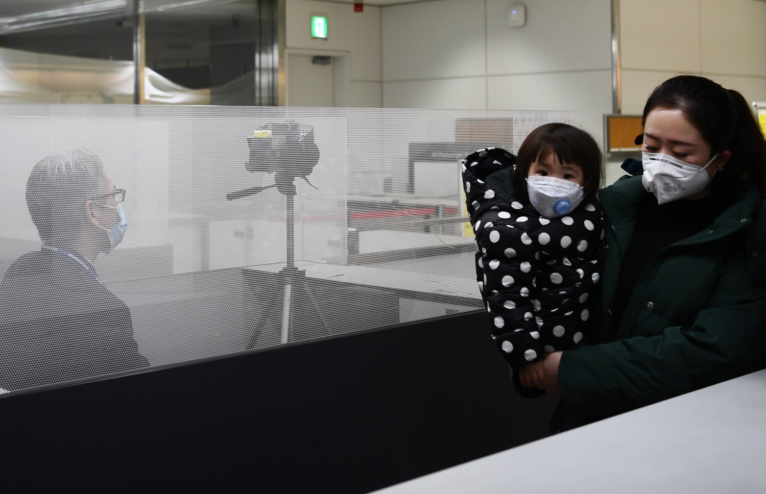 ވުހާން ސިޓީން ދަތުރު ކުރި ބަޔަކު ޖަޕާނުގެ ނަރީޓާ އެއާޕޯޓުގައި ސްކްރީން ކުރަނީ. --ފޮޓޯ:އޭއެފްޕީ