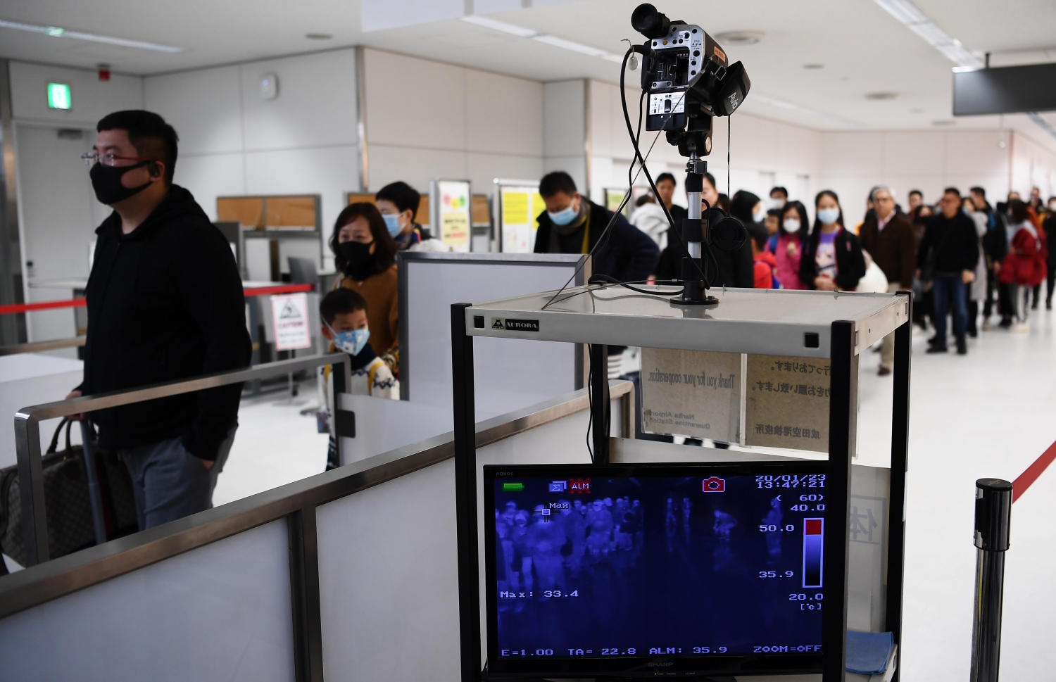 ވުހާން ސިޓީން ދަތުރު ކުރި ބަޔަކު ޖަޕާނުގެ ނަރީޓާ އެއާޕޯޓުގައި ސްކްރީން ކުރަން ދަނީ. --ފޮޓޯ:އޭއެފްޕީ