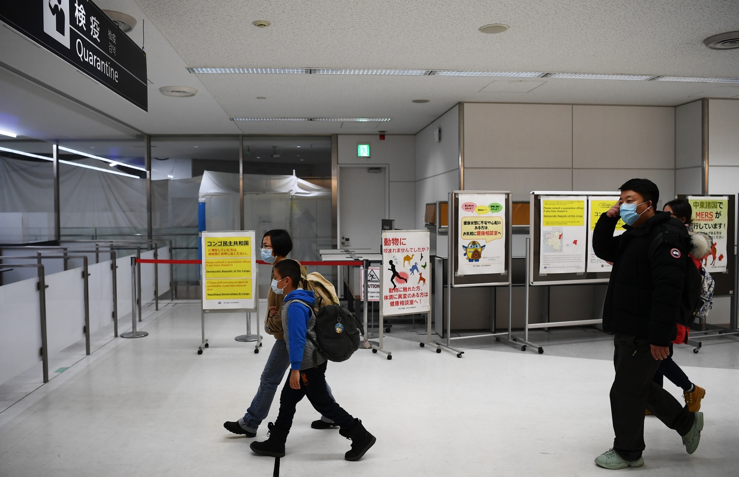 ވުހާން ސިޓީން ދަތުރު ކުރި ބަޔަކު ޖަޕާނުގެ ނަރީޓާ އެއާޕޯޓުގައި ސްކްރީން ކުރަން ދަނީ. --ފޮޓޯ:އޭއެފްޕީ