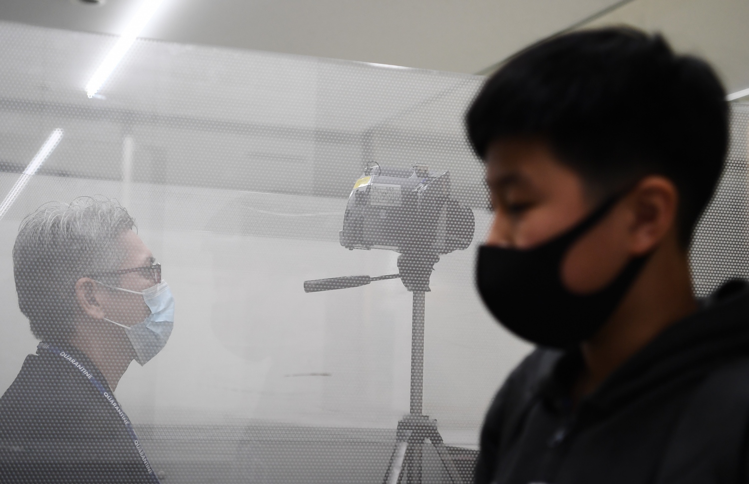 ވުހާން ސިޓީން ދަތުރު ކުރި މީހަކު ޖަޕާނުގެ ނަރީޓާ އެއާޕޯޓުގައި ސްކްރީން ކުރަނީ. --ފޮޓޯ:އޭއެފްޕީ