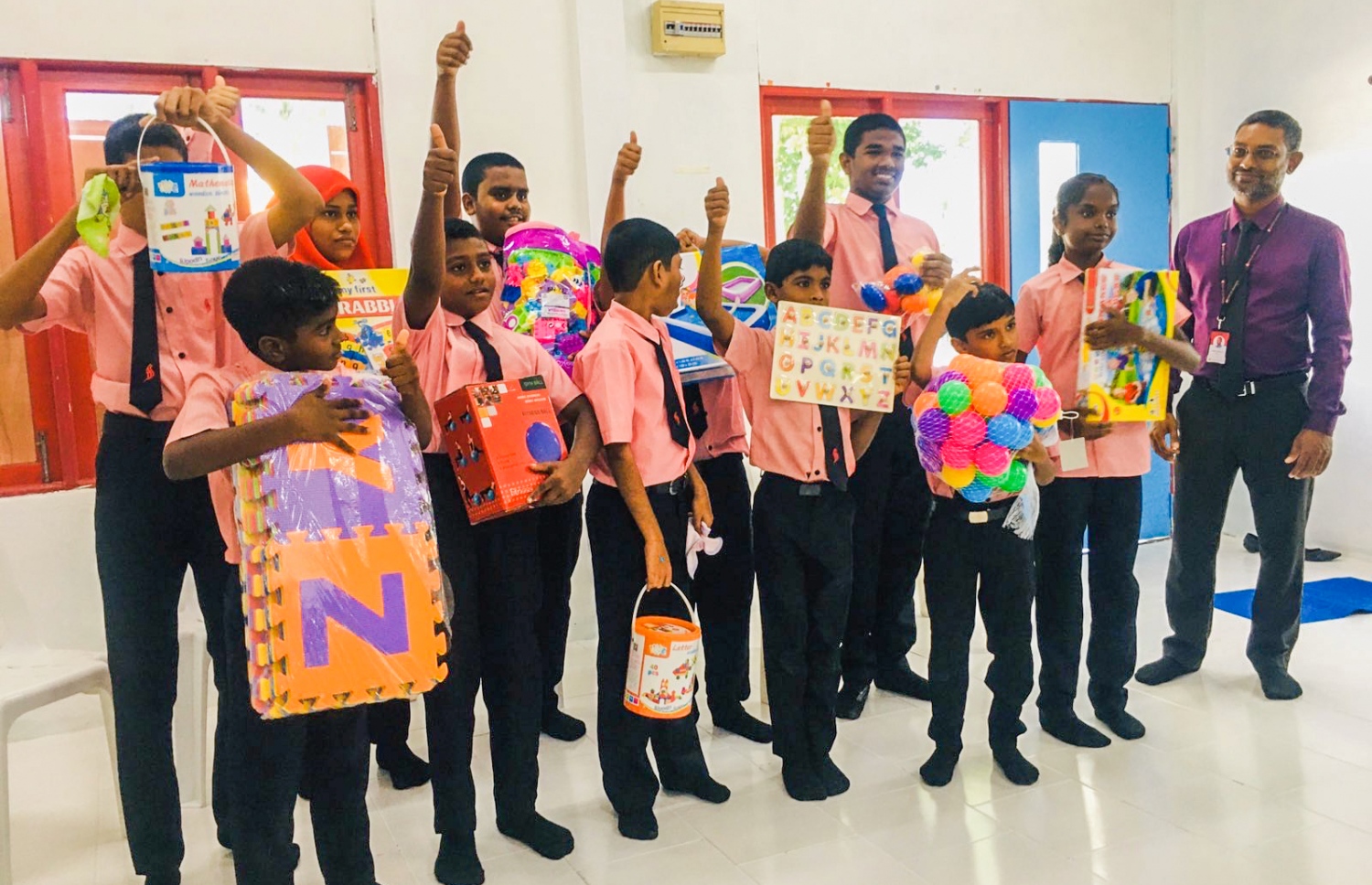 ތިނަދޫ އަބޫބަކުރު ސްކޫލް ސެން ކްލާހުގެ ދަރިވަރުންތަކެއް ބީއެމްއެލުން ހަދިޔާ ކުރި ތަކެތި ހިފަހައްޓައިގެން -- ފޮޓޯ: ބީއެމްއެލް