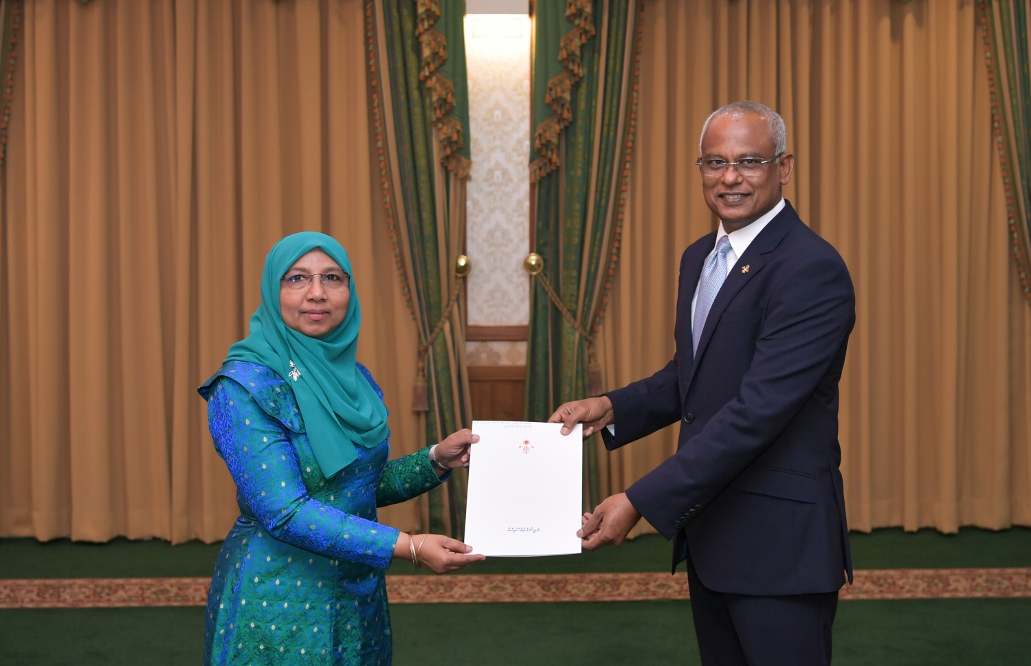 މާލެ: ފެބްރުއަރީ 9، 2020- ޖެންޑާ މިނިސްޓަރަކަށް، މި ސަރުކާރުގައި އަލަށް އައްޔަން ކުރެއްވި އާއިޝަތު މުހައްމަދު ދީދީ އަށް، ރައީސް އިބްރާހިމް މުހައްމަދު ސޯލިހު މަގާމުގެ ފަތްކޮޅު މިއަދު އަރުވަނީ: މި ސަރުކާރުގައި މިހާތަނަށް އެކަމަނާ ހުންނެވީ އިންޑިއާގައި ހުންނަވާ ރާއްޖޭގެ ސަފީރުކަމުގެ މަގާމުގައި.---ފޮޓޯ: ރައީސް އޮފީސް