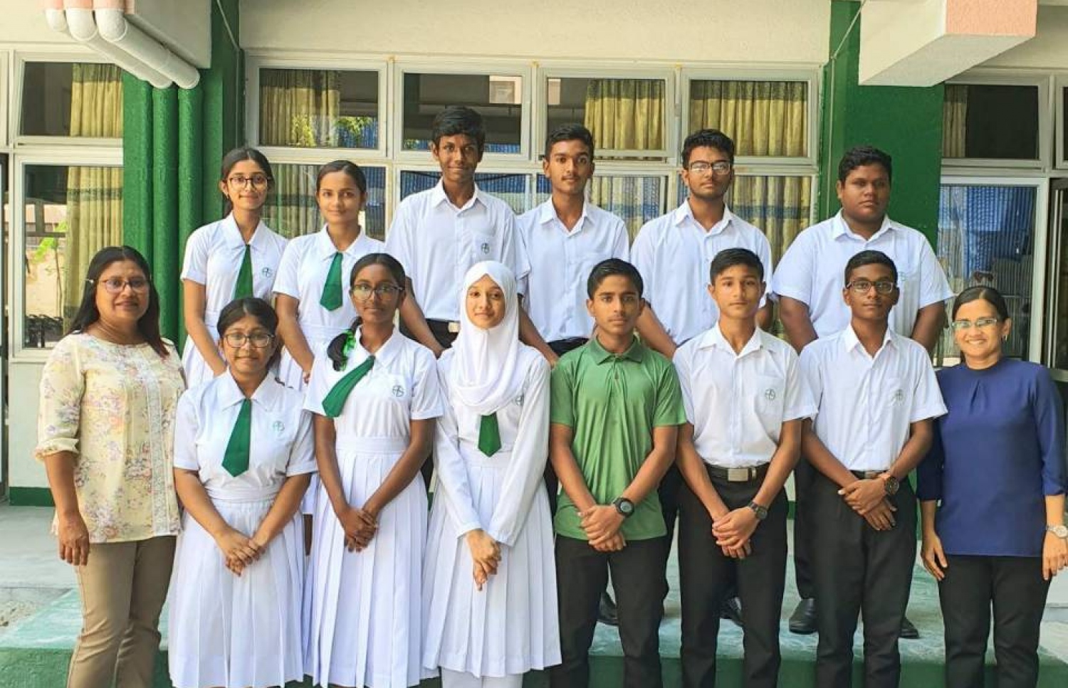 އަމީނިއްޔާގެ އިސް މަގާމުތަކަށް ހޮވުނު ދަރިވަރުންނާއެކު، އެ ސްކޫލުގެ ޕްރިންސިޕަލް ނާޒް (ވ) އަދި ލީޑިން ޓީޗރު އައްޒަ ފޮޓޯއަކަށް ހުއްޓިލައިގެން.-- ފޮޓޯ: އަމީނިއްޔާ ސްކޫލު