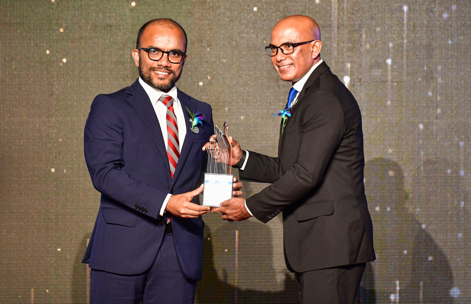 މާލެ: މާޗް 3، 2020- ސްޓެލްކޯ އިން ކަރަންޓުގެ ހިދުމަތަށް ދޭން ފެށިތާ 70 އަހަރު ފުރުން ފާހަގަ ކުރުމަށް ބޭއްވި ޚާއްސަ ޖަލްސާގާއި، އެ ކުންފުންޏަށް ގިނަ ދުވަސްތަކެއް ވަންދެން ޚިދުމަތް ކުރެއްވި، ރައީސް އޮފީހުގެ މިހާރުގެ މިނިސްޓަރު އަހުމަދު ސަމީރު (ކ) އަށް، ފިނޭންސް މިނިސްޓަރު އަމީން އެވޯޑް ދެއްވަނީ.---ފޮޓޯ: އަހުމަދު އަވްޝަން އިލްޔާސް/މިހާރު