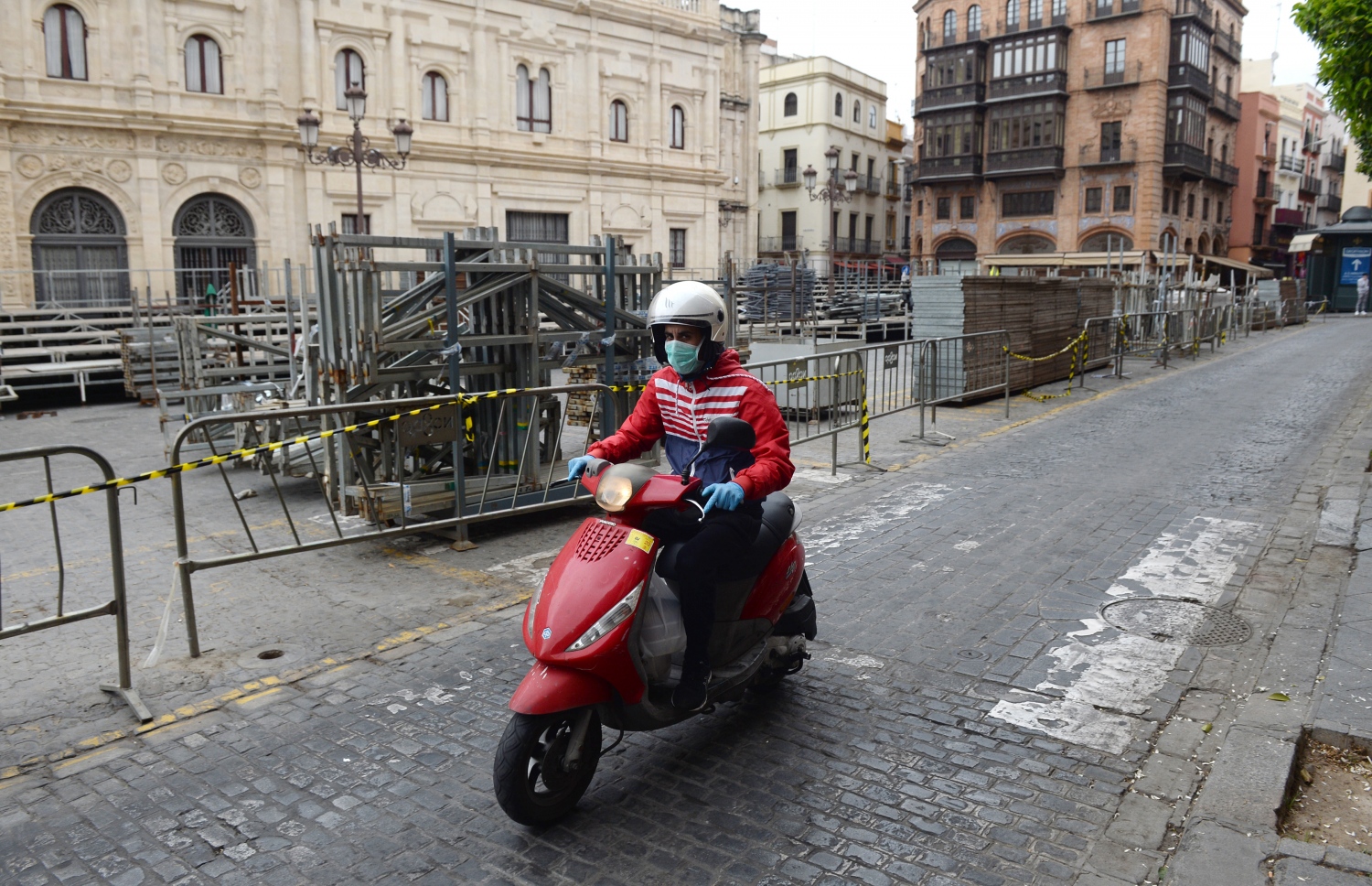 ސްޕޭނުގެ ސެވިއްޔާގެ މަގަކުން މީހަކު ސައިކަލެއްގައި ދަނީ: ސްޕޭނުގައި މީހުން ބޭރަށް ނުކުމެ އުޅުން ވަނީ މަނާކޮށްފައި. --ފޮޓޯ:އޭއެފްޕީ