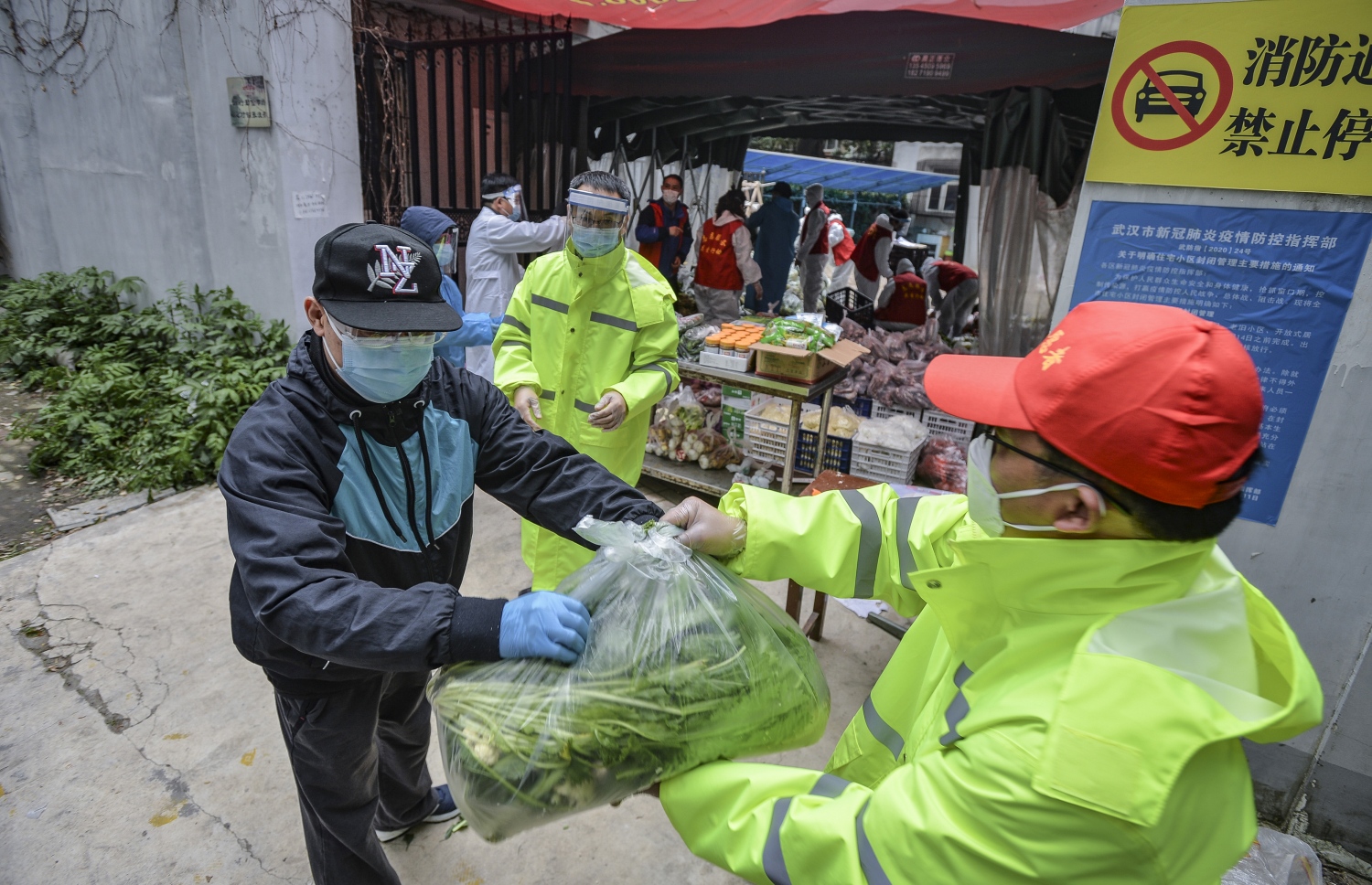 ވޫހާން ސިޓީގައި ތަރުކާރީ އަށް އޯޑަރުކުރި މީހުންނަށް ވޮލަންޓިއަރުން ތަކެތި ފޯރުކޮށްދެނީ --ފޮޓޯ:އޭއެފްޕީ