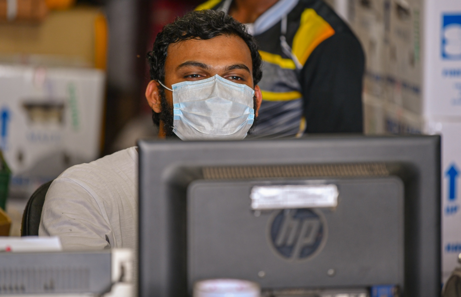 ކޮވިޑް-19 އިން ސަލާމަތް ވުމަށް މާސްކް އަޅައިގެން ހުރި މީހަކު ކޮންޕިއުޓަރާ ކުޅެނީ: ބައްޔާ ގުޅިގެން ގިނަ ބައެއްގެ މެދުގައި ވަނީ ބިރުވެރިކަން އުފެދިފައި-- ފޮޓޯ: އަހުމަދު އަވްޝަން/މިހާރު