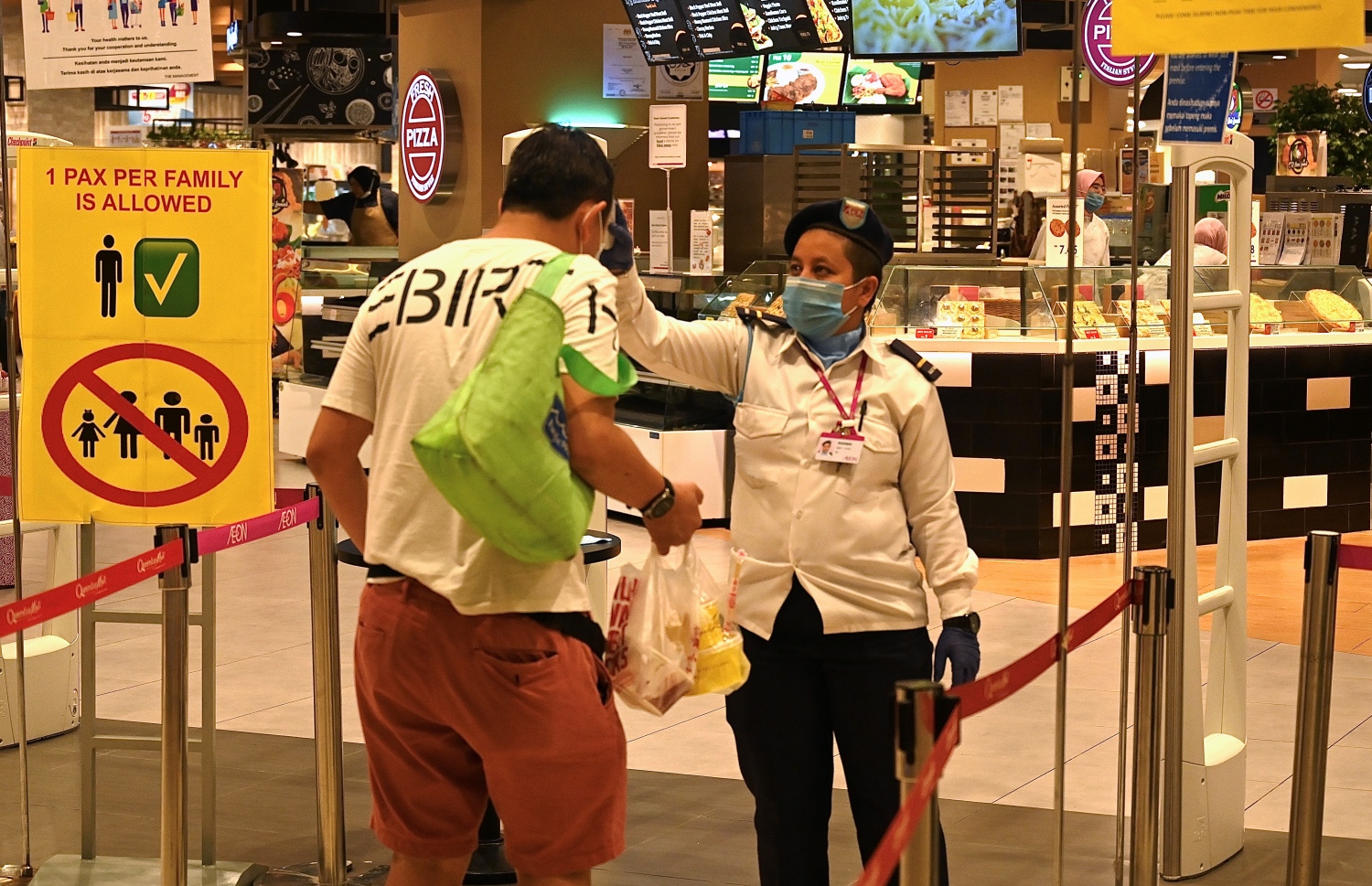 މެލޭޝިއާގެ ސުޕަމާކެޓަކަށް ވަންނަ ކަސްޓަމަރެއްގެ ޓެމްޕަރޭޗާ ޗެކް ކުރަނީ. --ފޮޓޯ:އޭއެފްޕީ