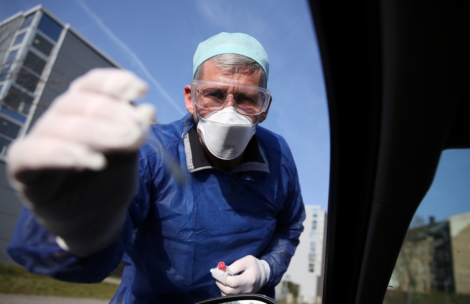 ކާރެއްގެ ތެރޭގައި އިން ޑްރައިވަރެއްގެ ސާމްޕަލް ޖަރުމަނުގެ ޑޮކްޓަރަކު ނަގަނީ. --ފޮޓޯ:އޭއެފްޕީ