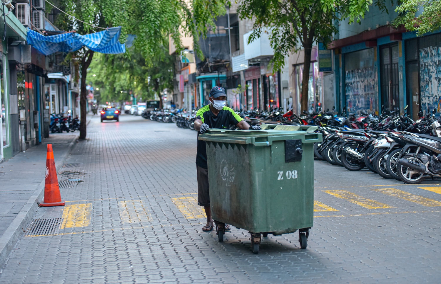 މާލެ: އޭޕްރިލް 2، 2020- މާލޭގައި މިއަދު ކާފިއު ހިންގާފައި އޮތް ވަގުތު، ވެމްކޯގެ މީހަކު ގޭގެއިން ކުނި ނެގުމުގައި.---ފޮޓޯ: އަހުމަދު އަވްޝަން/މިހާރު