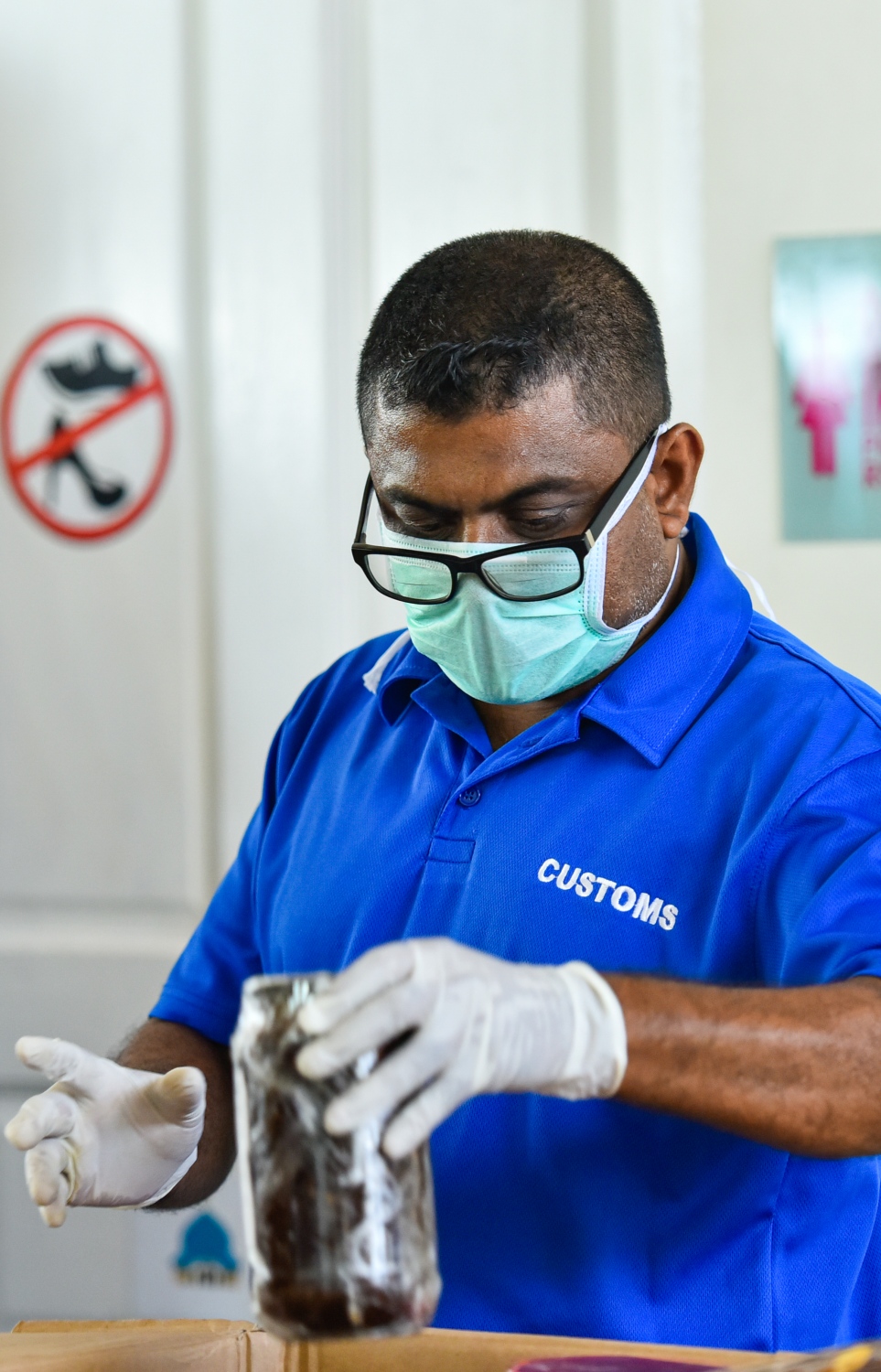 މާލެ- އޭޕްރީލް 4، 2020- ރާއްޖޭގެ ގައުމީ އެއާލައިން މޯލްޑިވިއަން އިން ސްރީ ލަންކާ އަށް ބާއްވާ ކާގޯ ދަތުރުގައި، އެ ގައުމުގައި އުޅޭ ދިވެހި އާއިލާ އަކަށް މީހަކު ފޮނުވާ ރިހާކުރުފުޅިއެއް، ކަސްޓަމްސް އޮފިސަރަކު ޗެކް ކުރަނީ.---ފޮޓޯ: އަހުމަދު އަވްޝަން/މިހާރު