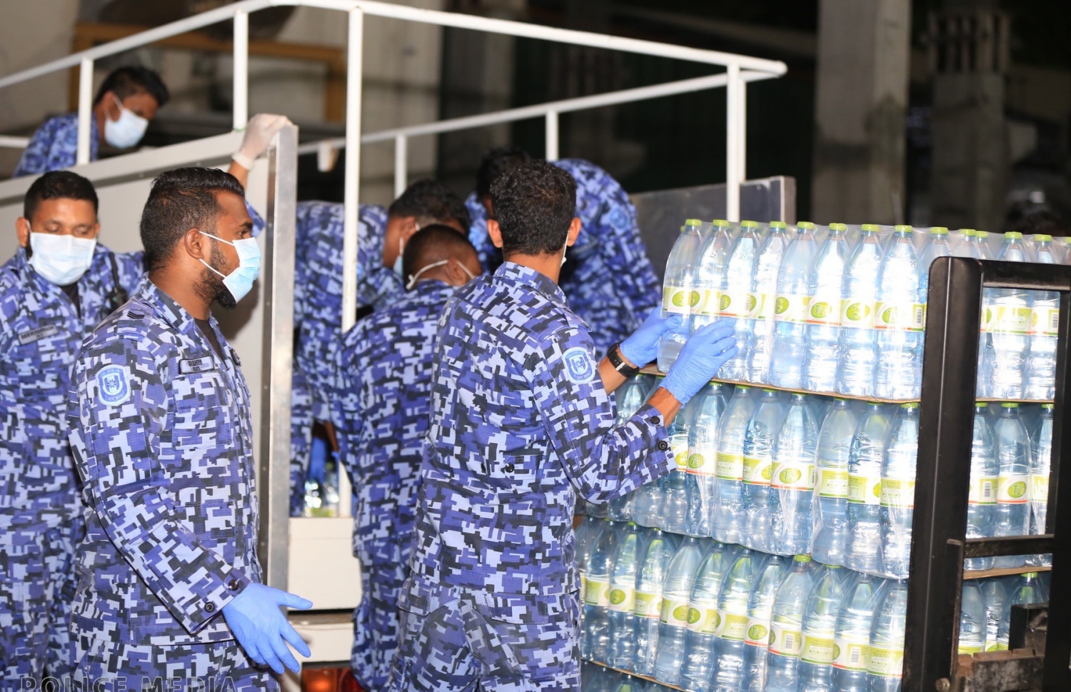 މާލޭގެ ގޭގެ އަށް ތާޒާ ފެން ޑެލިވަރީ ކުރުމުގައި ފުލުހުންތަކެއް މަސައްކަތުގައި: ކޮވިޑް-19 އާ ގުޅިގެން ފުލުހުން ވެސް ތިބީ އެލާޓްގައި.---ފޮޓޯ؛ ޕޮލިސް