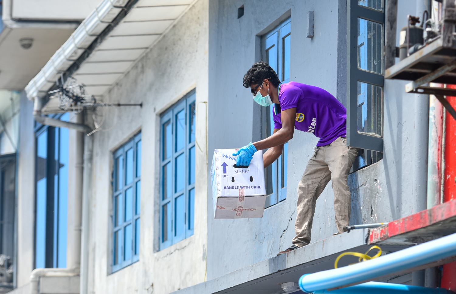 މާލެ: އޭޕްރިލް 19، 2020: ބާޒާރުމަތީގައި ހުރި ފިހާރައަކުން މީހަކު ޑެލިވަރީގެ ހިދުމަތް މުދާ ބޭރުކުރަނީ.-- ފޮޓޯ: އަހުމަދު އަވްޝަން /މިހާރު