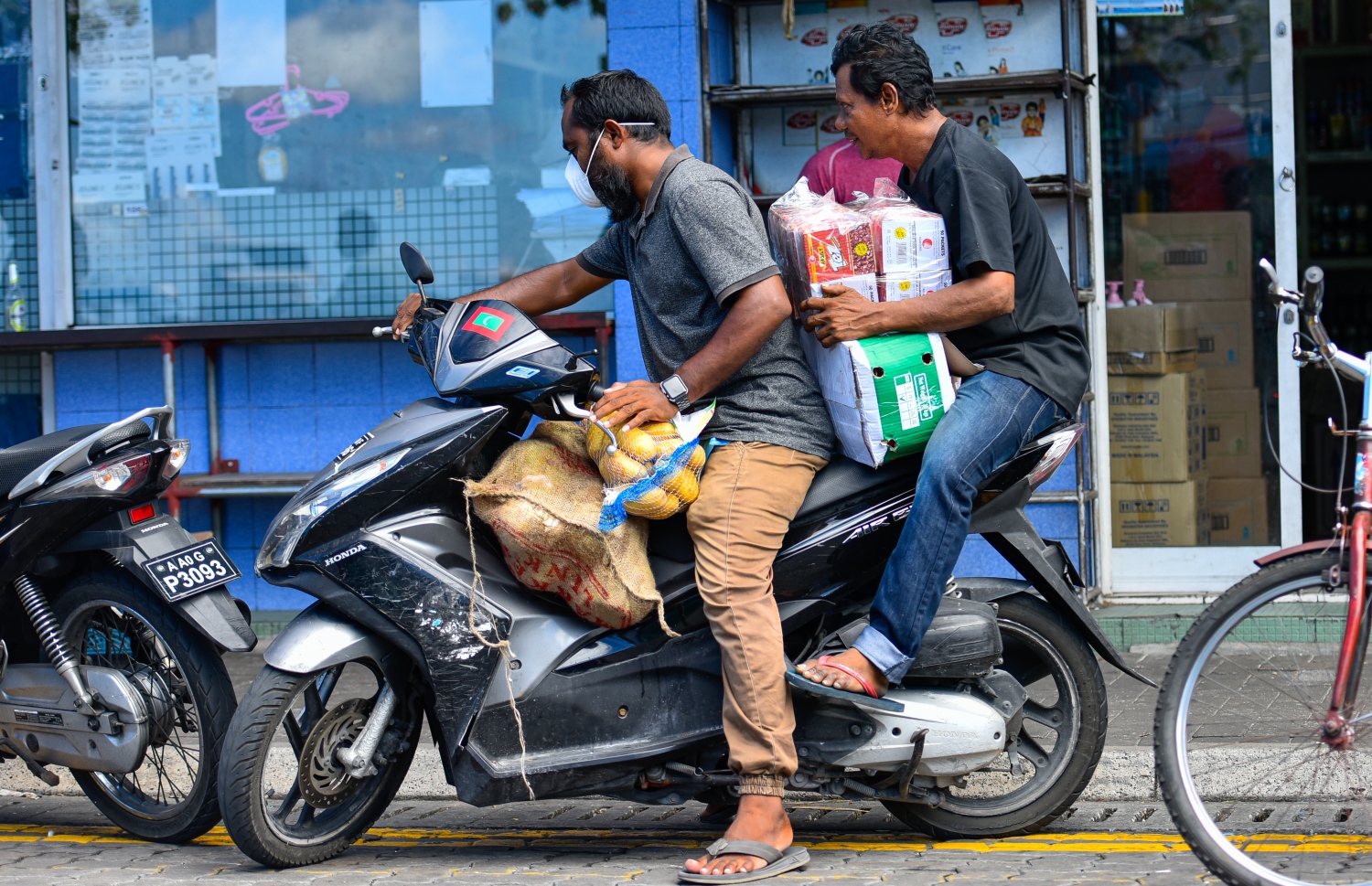 މާލެ: އޭޕްރިލް 19، 2020: ބާޒާރުމަތީގައި ބަޔަކު ސައިކަލުގައި މުދާ އުފުލަނީ.-- ފޮޓޯ: އަހުމަދު އަވްޝަން /މިހާރު