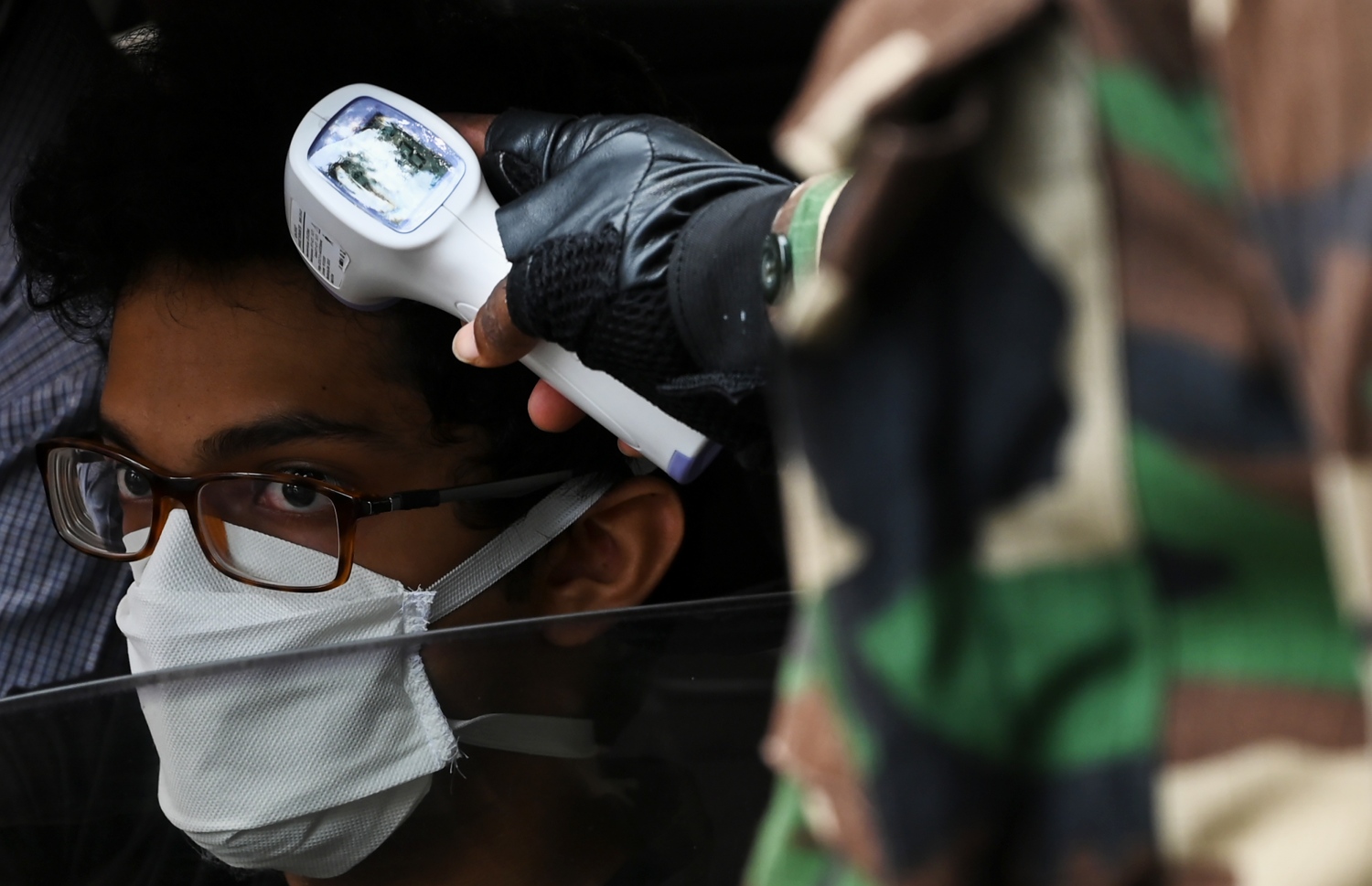 ކޮލަމްބޯ - އެޕްރީލް 29: ސްރީ ލަންކާ ލޮކްޑައުންކޮށްފައިވާ އިރު ވެރިރަށް ކޮލަމްބޯގެ މަގެއްގައި ސިފައިންގެ މީހަކު، މީހެއްގެ ހުން ބަލަނީ. --ފޮޓޯ:އޭއެފްޕީ