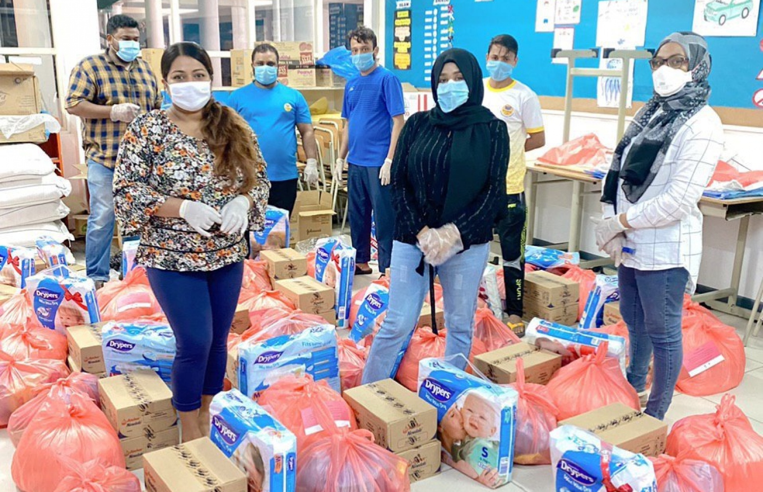 ހާލުގައި އުޅޭ މައިންނަށް ދޭން މަމްސް އިން ތައްޔާރުކޮށްފައިވާ ޕެކްތަކެއް ކައިރީގައި އެހީތެރިން -- ފޮޓޯ: މަމްސް އެންޖީއޯ