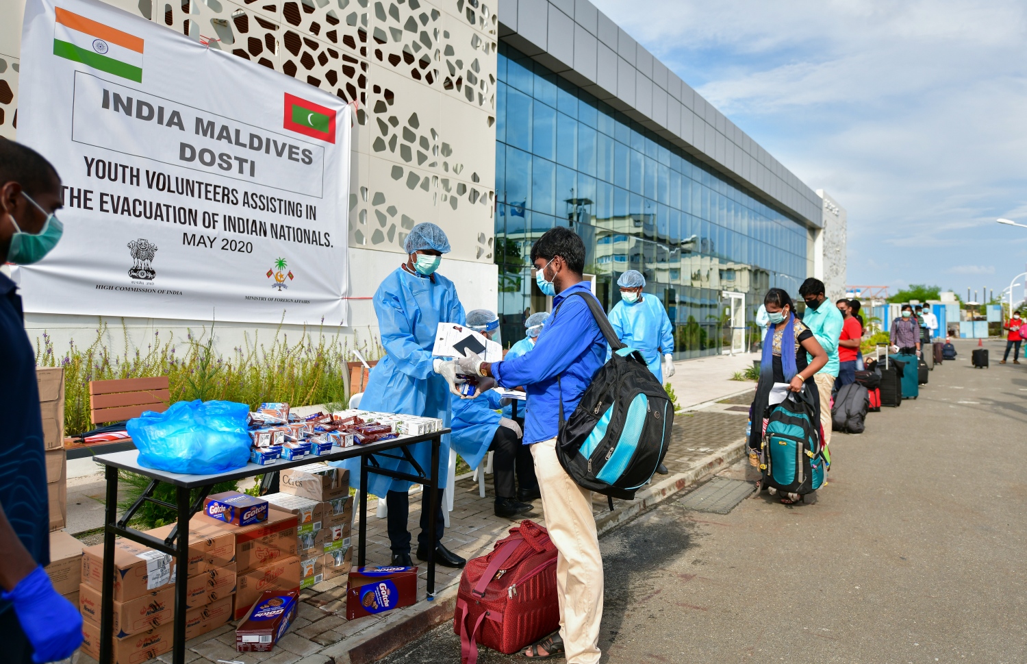 މޭ 8، 2020- ކޮވިޑް-19 އާ ގުޅިގެން ރާއްޖޭގައި ތާށިވެފައި ތިބި އިންޑިއާގެ މީހުން އަނބުރާ ގައުމަށް ގެންދިއުމުގެ ކުރިން އިމިގްރޭޝަންގެ ކަންކަން ނިންމުމަށް ވެލާނާ އިންޓަނޭޝަނަލް އެއާޕޯޓަށް ގެންގޮސްދިނުމުގައި އެހީތެރިވި މީހުން ރައްކާތެރިކަމުގެ ޚާއްސަ ހެދުމުގައި: އެ މީހުން ބަލާ ރާއްޖެ އައި އިންޑިއާގެ ޚާއްސަ މަނަވަރުގައި 698 މީހަކު ގެންދިޔަ.---ފޮޓޯ: އަހުމަދު އަވްޝަން/މިހާރު