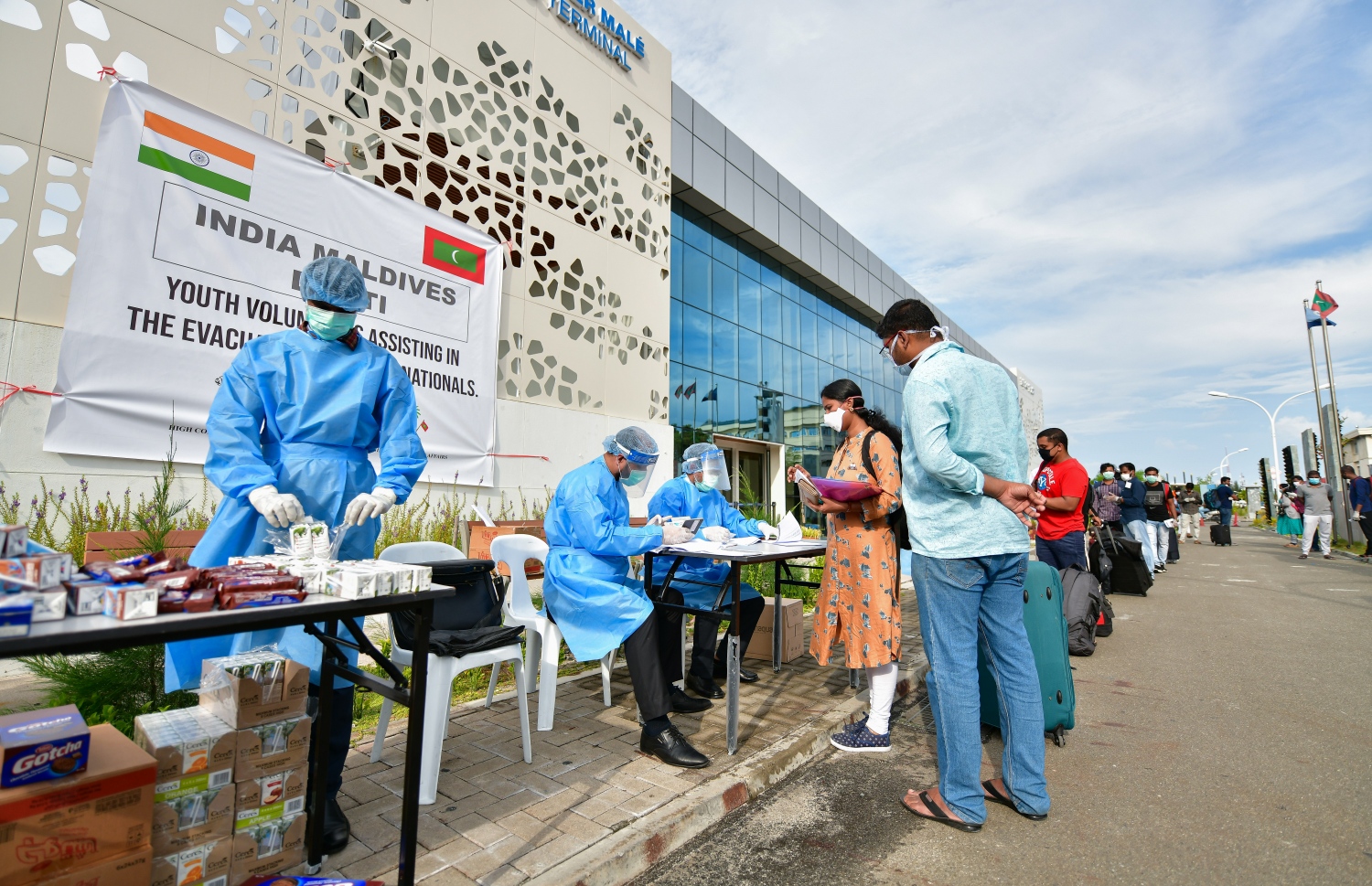 މޭ 8، 2020- ކޮވިޑް-19 އާ ގުޅިގެން ރާއްޖޭގައި ތާށިވެފައި ތިބި އިންޑިއާގެ މީހުން އަނބުރާ ގައުމަށް ގެންދިއުމުގެ ކުރިން އިމިގްރޭޝަންގެ ކަންކަން ނިންމުމަށް ވެލާނާ އިންޓަނޭޝަނަލް އެއާޕޯޓަށް ގެންގޮސްދިނުމުގައި އެހީތެރިވި މީހުން ރައްކާތެރިކަމުގެ ޚާއްސަ ހެދުމުގައި: އެ މީހުން ބަލާ ރާއްޖެ އައި އިންޑިއާގެ ޚާއްސަ މަނަވަރުގައި 698 މީހަކު ގެންދިޔަ.---ފޮޓޯ: އަހުމަދު އަވްޝަން/މިހާރު