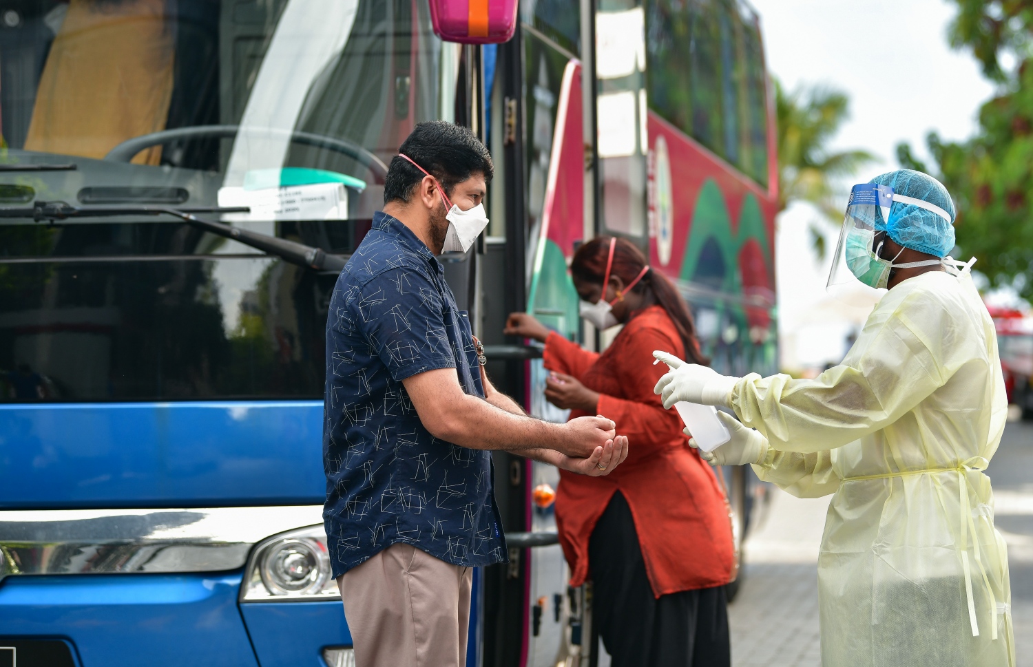 މޭ 8، 2020- ކޮވިޑް-19 އާ ގުޅިގެން ރާއްޖޭގައި ތާށިވެފައި ތިބި އިންޑިއާގެ މީހުން އަނބުރާ ގައުމަށް ގެންދިއުމުގެ ކުރިން އިމިގްރޭޝަންގެ ކަންކަން ނިންމުމަށް އެމްޕީއެލްގެ ބަހުގައި ވެލާނާ އިންޓަނޭޝަނަލް އެއާޕޯޓަށް ގެންދާއިރު، ބަހަށް އަރާ މީހުން ސެނިޓައިޒް ކުރަނީ: އެ މީހުން ބަލާ އައި އިންޑިއާގެ މަނަވަރުގައި 698 މީހަކު ގެންދިޔަ.---ފޮޓޯ: އަހުމަދު އަވްޝަން/މިހާރު