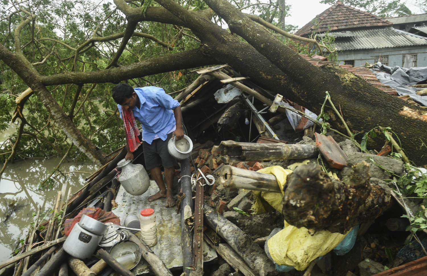 ކަލްކަތާ - މެއި 21، 2020: ތޫފާން އަމްފާންގައި ގެއްލުން ލިބުނު ގެއަކުން މީހަކު އެއްޗެހި ސަލާމަތް ކުރެވޭތޯ ބަލަނީ. --ފޮޓޯ:އޭއެފްޕީ