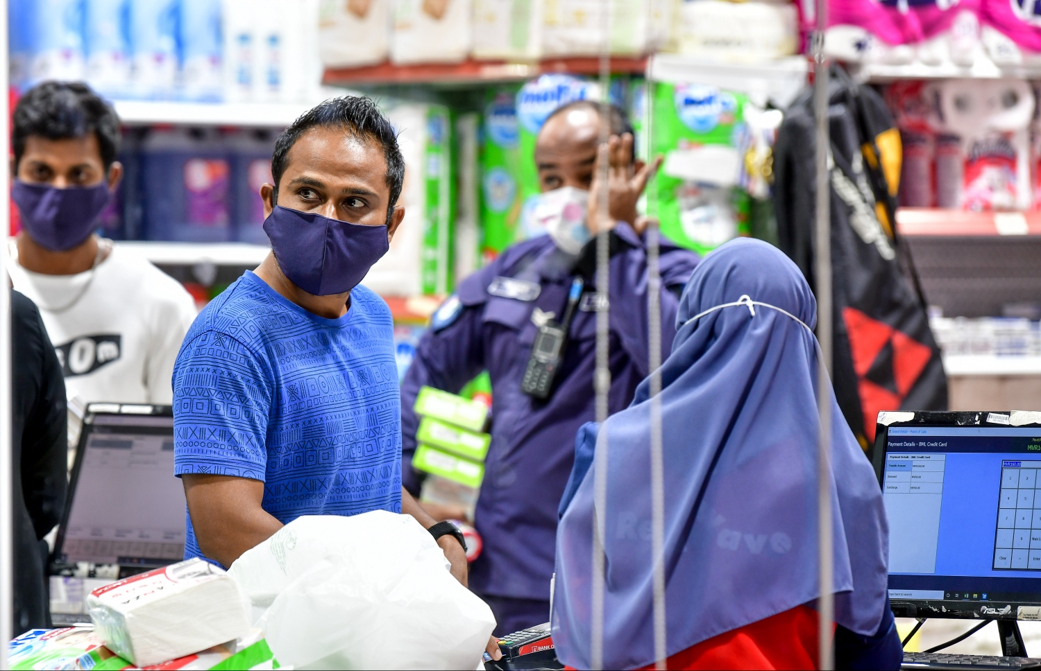 ހުޅުމާލެ: މެއި 21، 2020- ހުޅުމާލެ ލޮކްޑައުންގައި އޮތްއިރު، ހުޅުމާލޭގެ ރެޑް ވޭވް ފިހާރައިން ބާޒާރުކުރާ ބަޔަކު މާސްކް އަޅައިގެން.---ފޮޓޯ: ނިޝާން އަލީ/މިހާރު