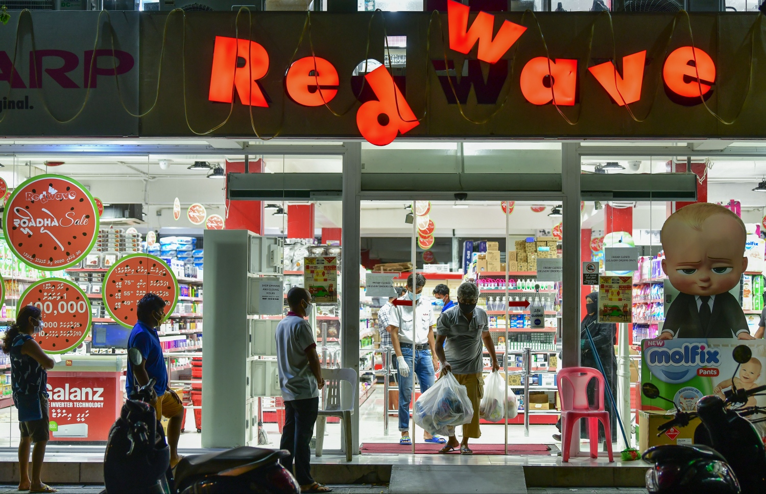 ހުޅުމާލެ: މެއި 21، 2020- ހުޅުމާލެ ލޮކްޑައުންގައި އޮތްއިރު، ހުޅުމާލޭގެ ރެޑް ވޭވް ފިހާރައިން އެއް ބަޔަކު ބާޒާރު ކޮށްގެން ނުކުންނައިރު، އަނެއް ބަޔަކު ބާޒާރު ކުރަން ވަންނަން ބޭރުގައި ކިއޫ ހަދާފައި: ކޮވިޑް-19 އިން ރައްކާތެރިވުމުގެ ގޮތުން، މި ދުވަސްވަރު މާލެ ސަރަހައްދުގެ ފިހާރަތަކުގައި ވަނީ ވަރުގަދަ ފިޔަވަޅުތަކެއް އަޅާފައި.---ފޮޓޯ: ނިޝާން އަލީ/މިހާރު