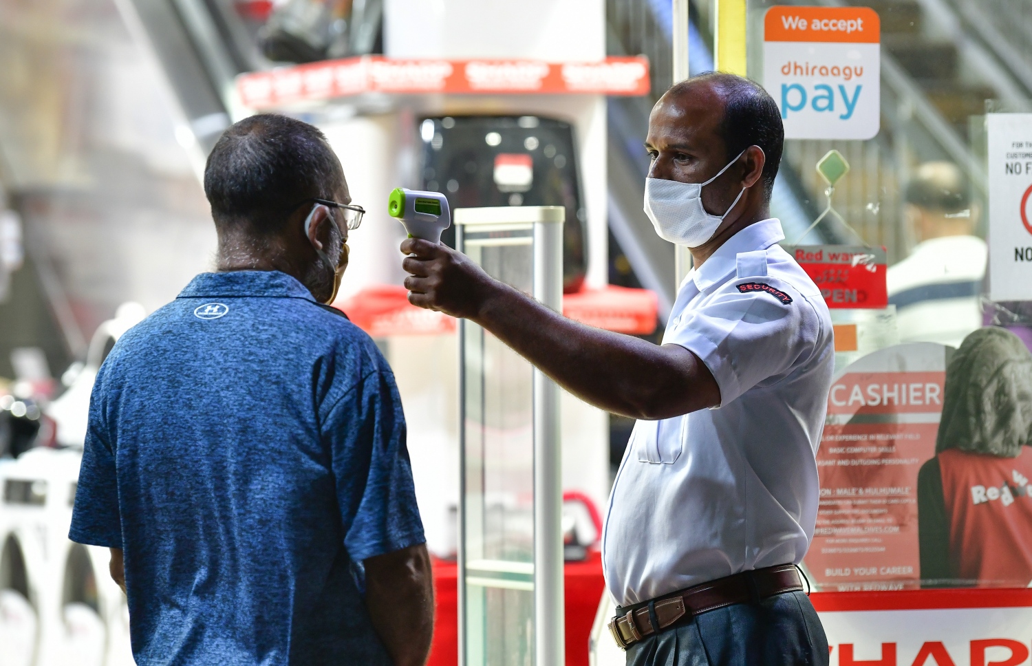 ހުޅުމާލެ: މެއި 21، 2020- ހުޅުމާލެ ލޮކްޑައުންގައި އޮތްއިރު، ބާޒާރުކުރަން ރެޑް ވޭވް ފިހާރައަށް ވަންނަ މީހެއްގެ ހުން ޗެކް ކުރަނީ.---ފޮޓޯ: ނިޝާން އަލީ/މިހާރު