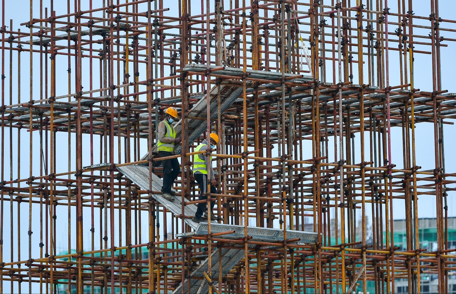 ހުޅުމާލެ: މެއި 21، 2020- ހުޅުމާލެ ލޮކްޑައުންގައި އޮތް އިރު، އިމާރާތް ކުރުމުގައި އުޅޭ ދެ ބިދޭސީއަކު ކޮވިޑް-19 އިން ރައްކާތެރިވުމަށް މާސްކް އަޅައިގެން މަސައްކަތުގައި.---ފޮޓޯ: ނިޝާން އަލީ/މިހާރު